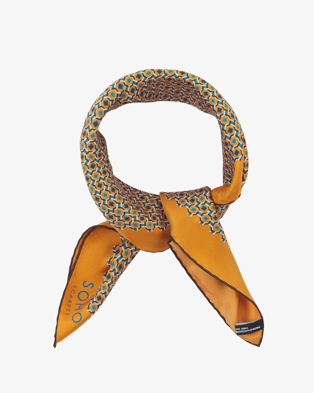The 'Berwick' neckerchief looped and knotted, highlighting the golden-orange silk and its sharp geometric print in turquoise, chocolate, and cream.