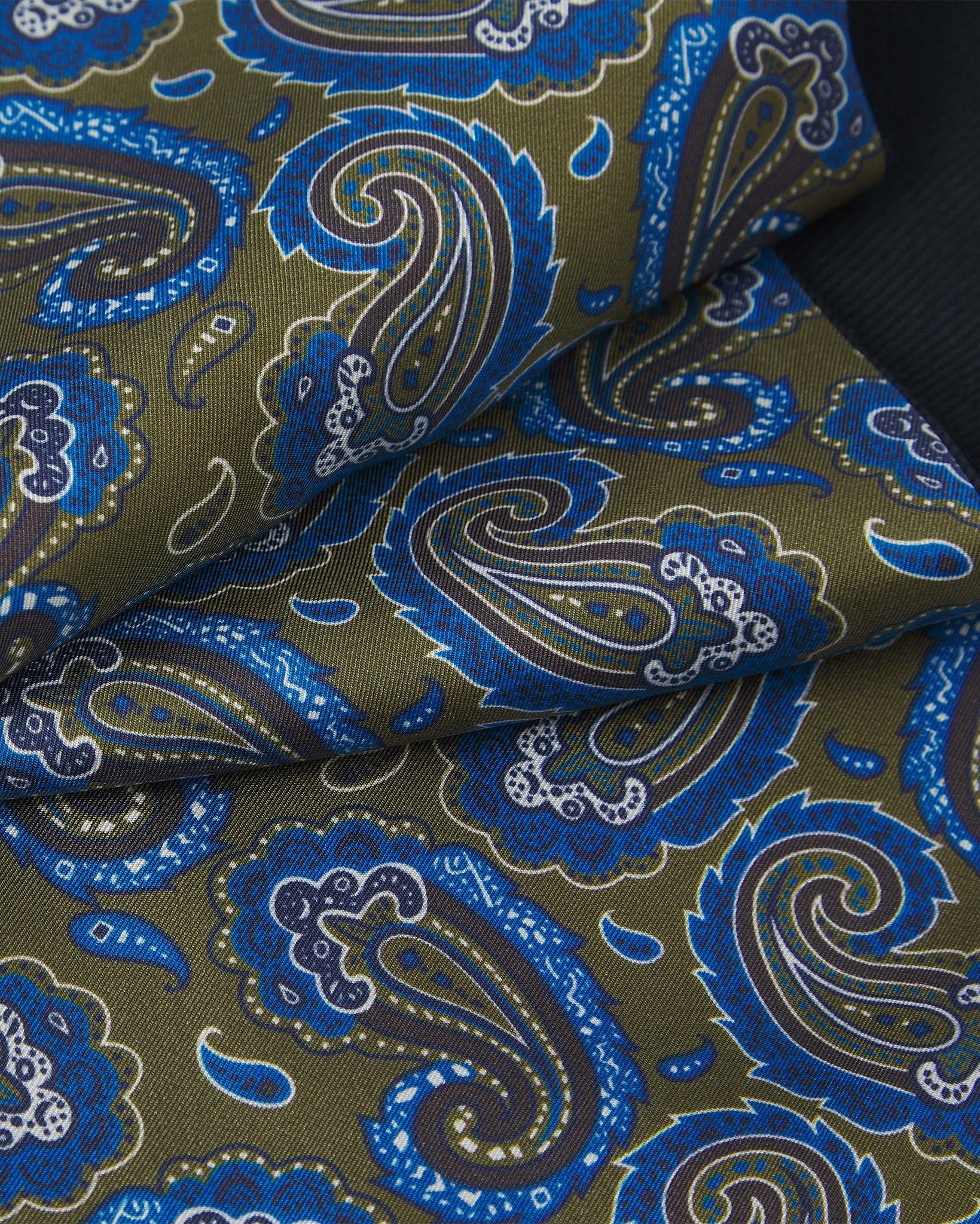 Ruffled close-up view of the Malibu silk scarf, presenting a closer view of the ornate green and blue paisley patterns.