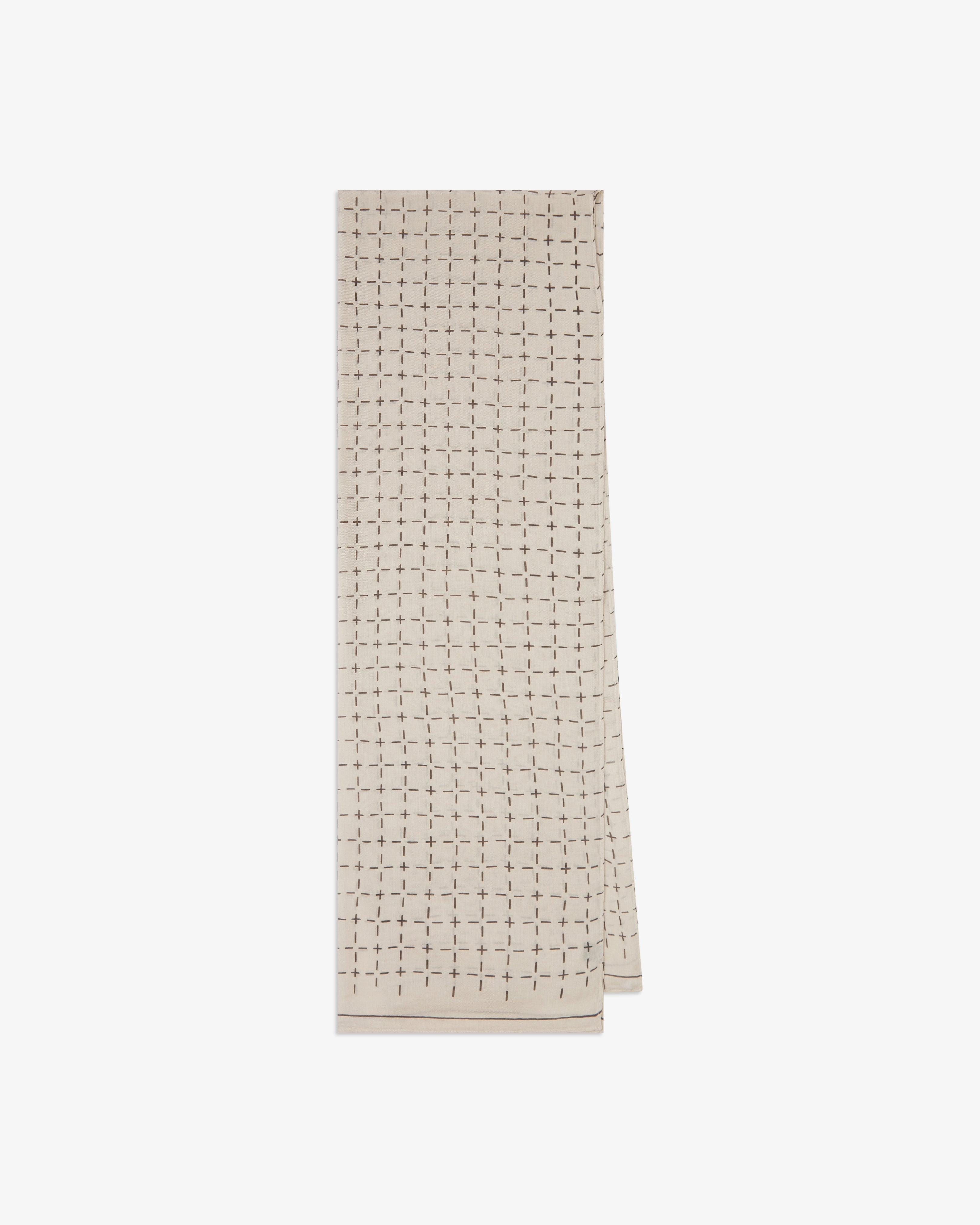 The 'Crosses' cream bohemian wide scarf from SOHO Scarves folded and presented vertically to show the full dimensions and repeating geometric grid pattern of dark grey dashes and crosses on a pale cream background.
