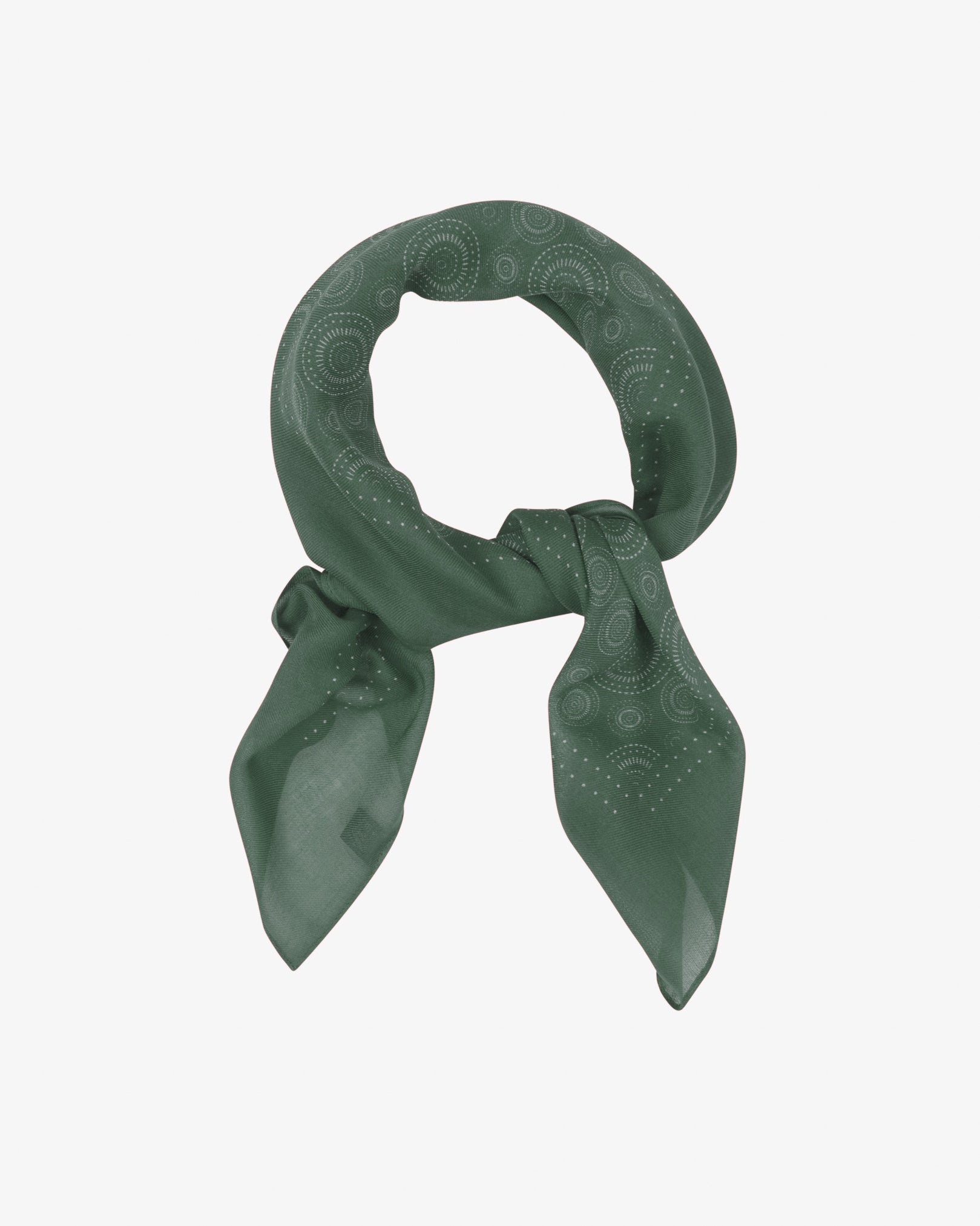 The 'Circles in Evergreen' modal and wool bandana loosely looped and knotted, showcasing concentric Op art-inspired disc motifs in deep evergreen tones across the soft modal and wool blend fabric.