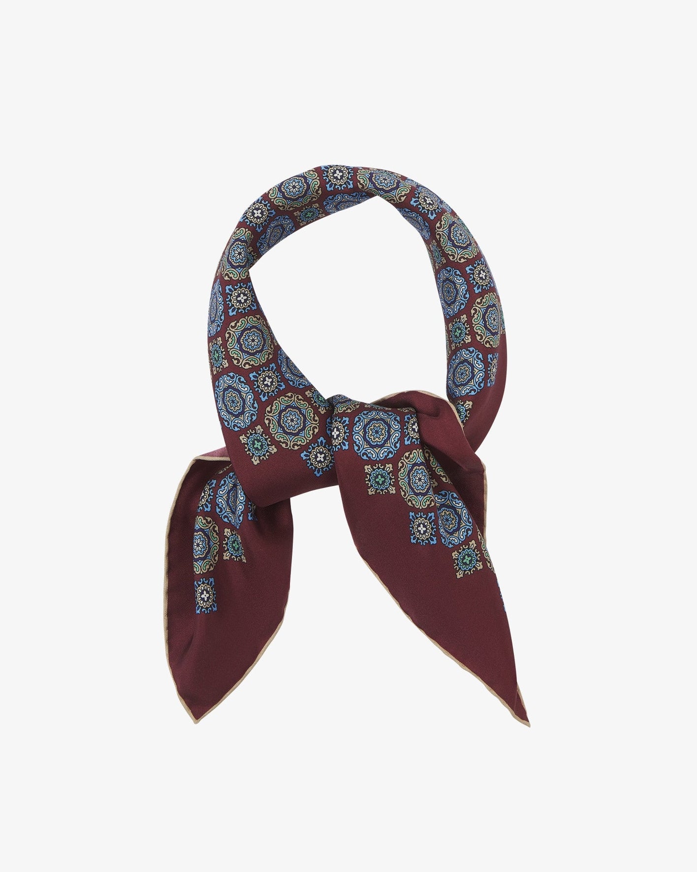 The 'Fitzrovia' neckerchief looped and knotted, showcasing the classic medallion design in soft blue, green, and ivory against a deep burgundy silk backdrop.