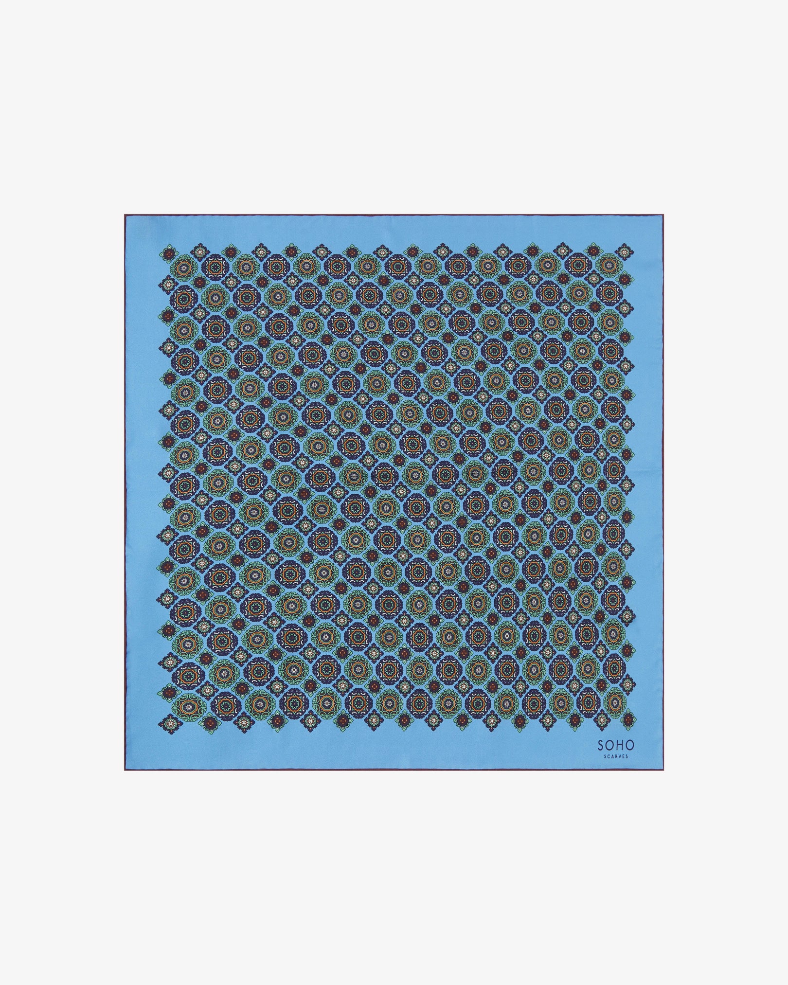 Fully unfolded 'Fitzrovia' silk neckerchief, clearly displaying the repeating medallion pattern in navy, green, and gold across a Leyland blue backdrop, finished with a fine burgundy edge.