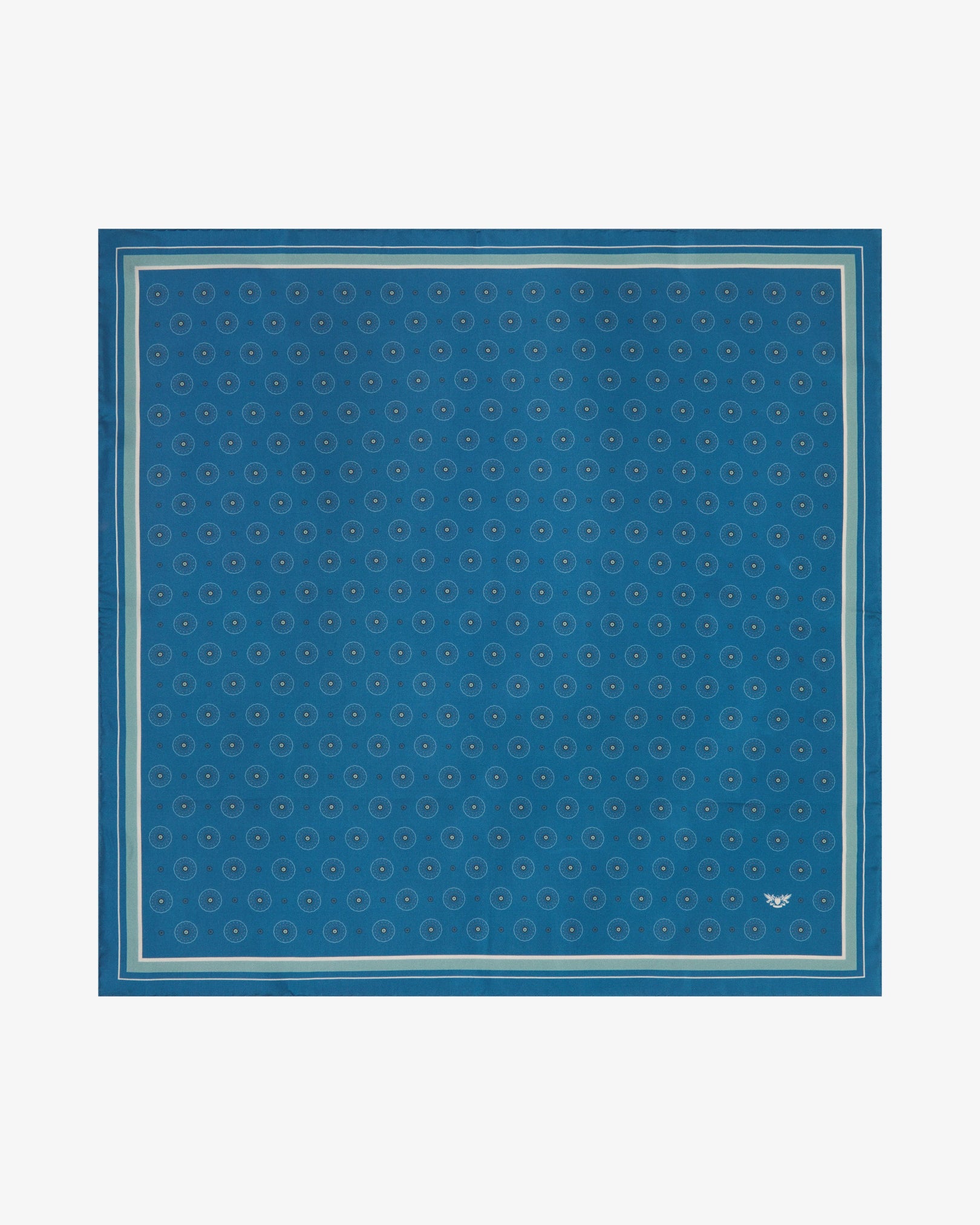 Fully unfolded 'Islington' silk neckerchief, revealing an all-over geometric circle and medallion pattern on a cornflower-slate blue background, framed by a slim mint-sage inner border and a soft blue-grey outer border.