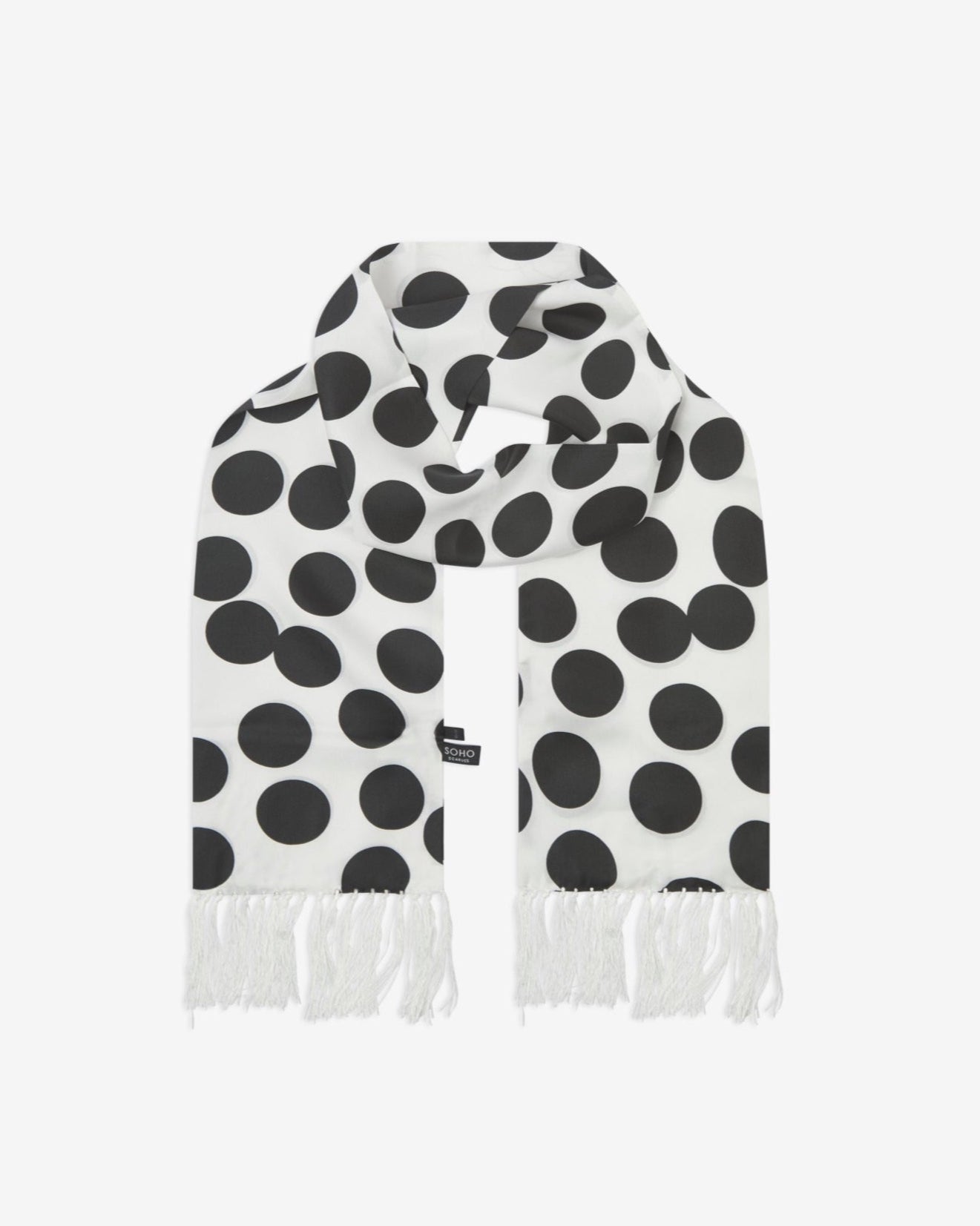 The Gable silk aviator scarf looped with both ends parallel to effectively display the white fringe and full repeat pattern of black discs on a white background.