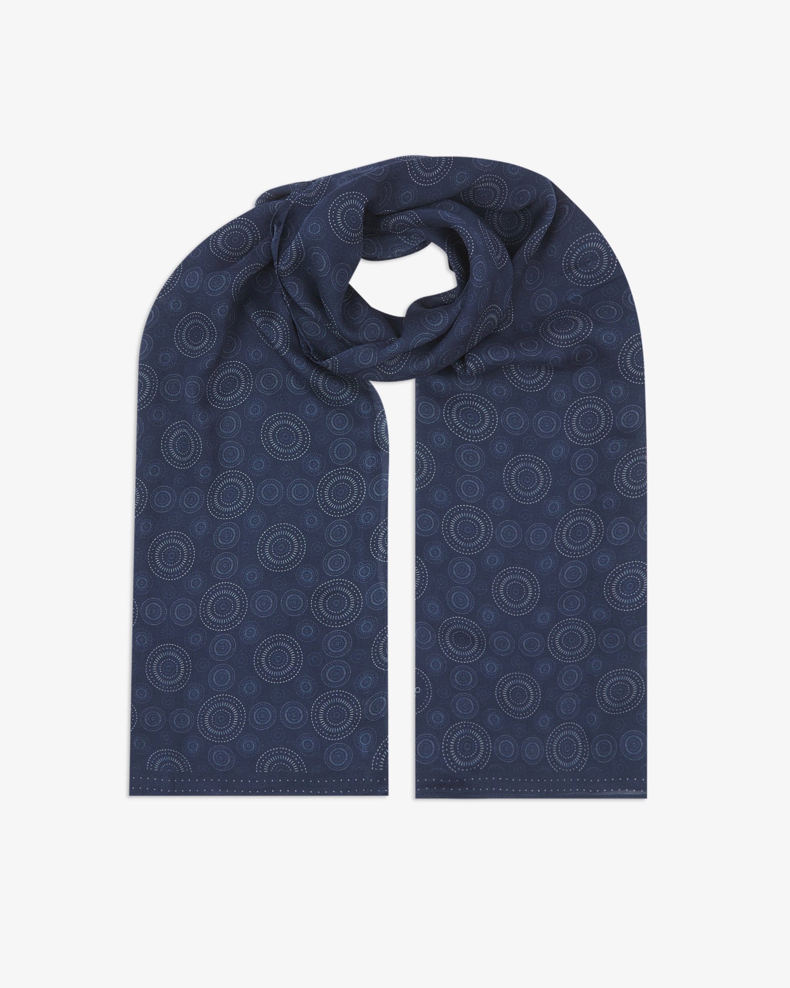 The 'Circles' indigo bohemian wide scarf looped with both ends parallel, showcasing concentric Op art-inspired disc motifs in white on a deep indigo-blue background across the soft modal and wool blend fabric.