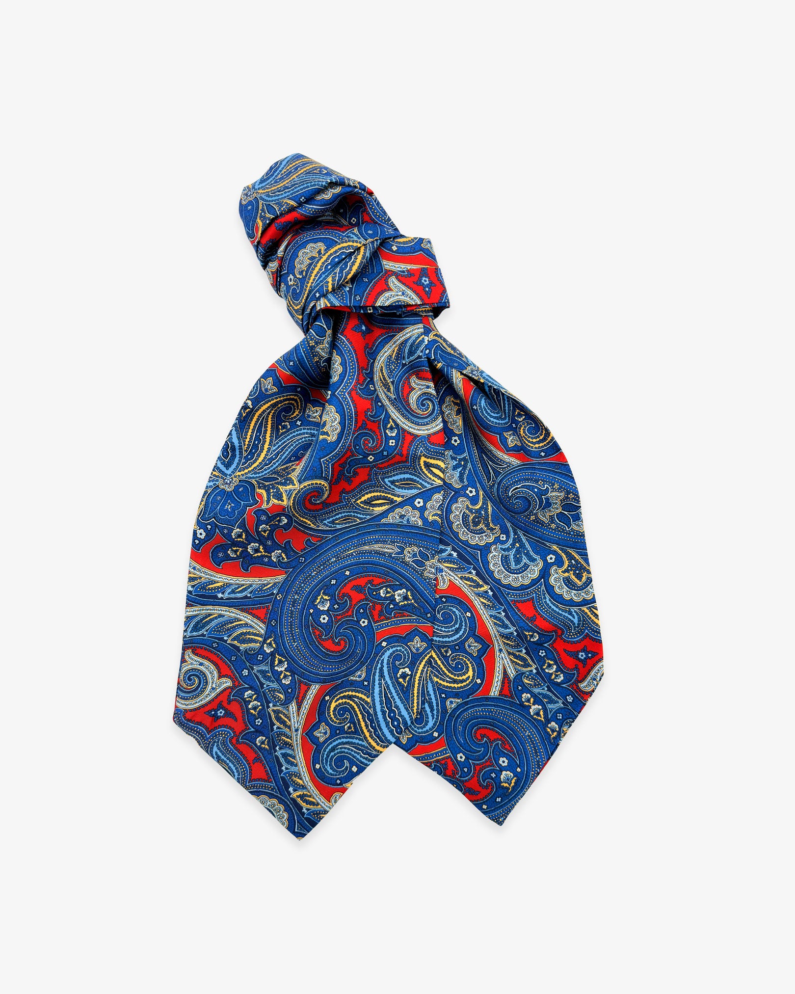 The Oxford double Ascot tie with wide ends at the bottom and clear view of the blue paisley patterns against a deep red ground.