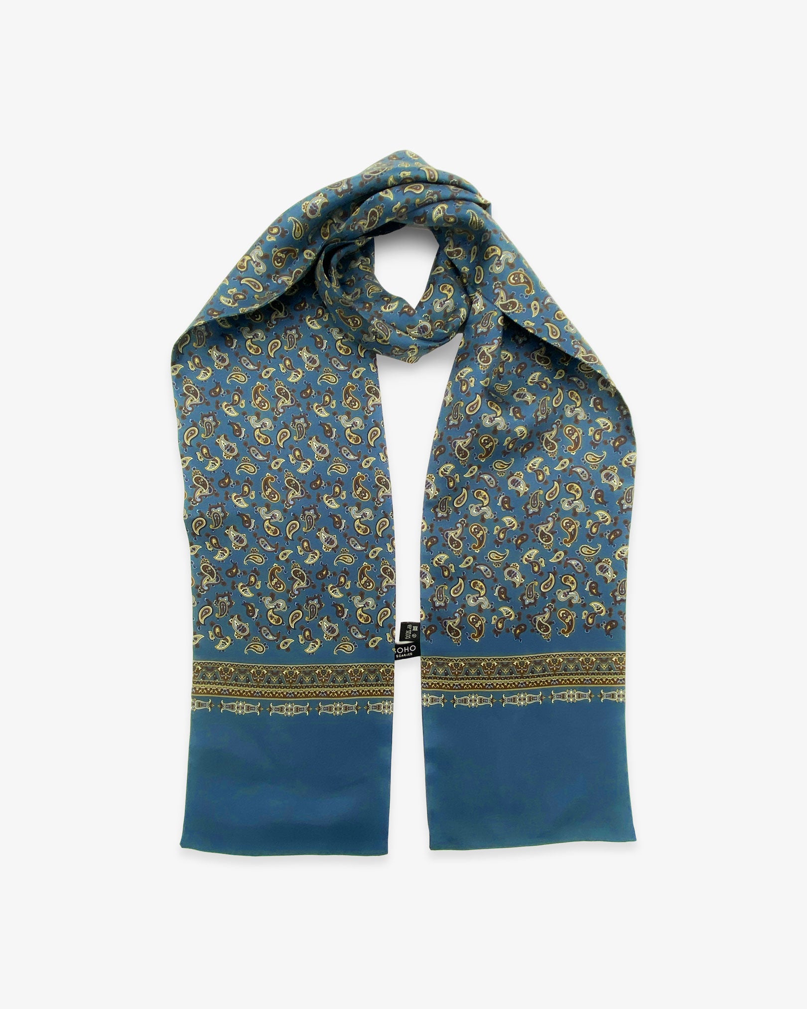 The Banff pure silk paisley scarf looped in middle with both ends parallel showing the paisley pure silk scarf on a peacock blue background. Clearly showing the blue, black and lemon yellow paisley patterns and the ornate, decorative border.