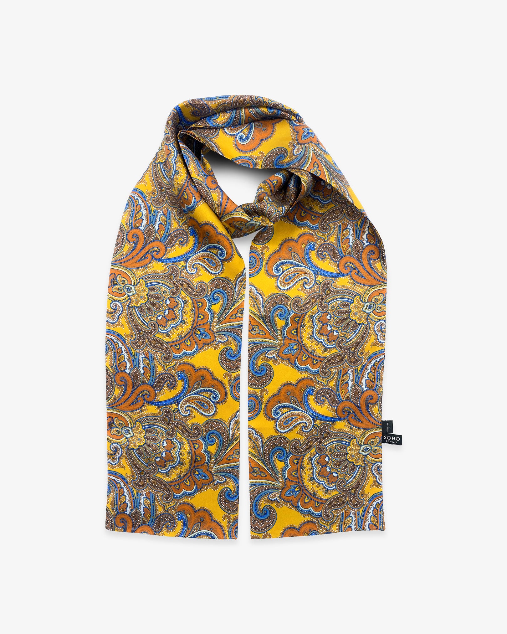 Looped view of the 'Carnaby' silk scarf, clearly showing the golden yellow fabric with vibrant orange, brown and blue paisley patterns and a matching 3-inch fringe.