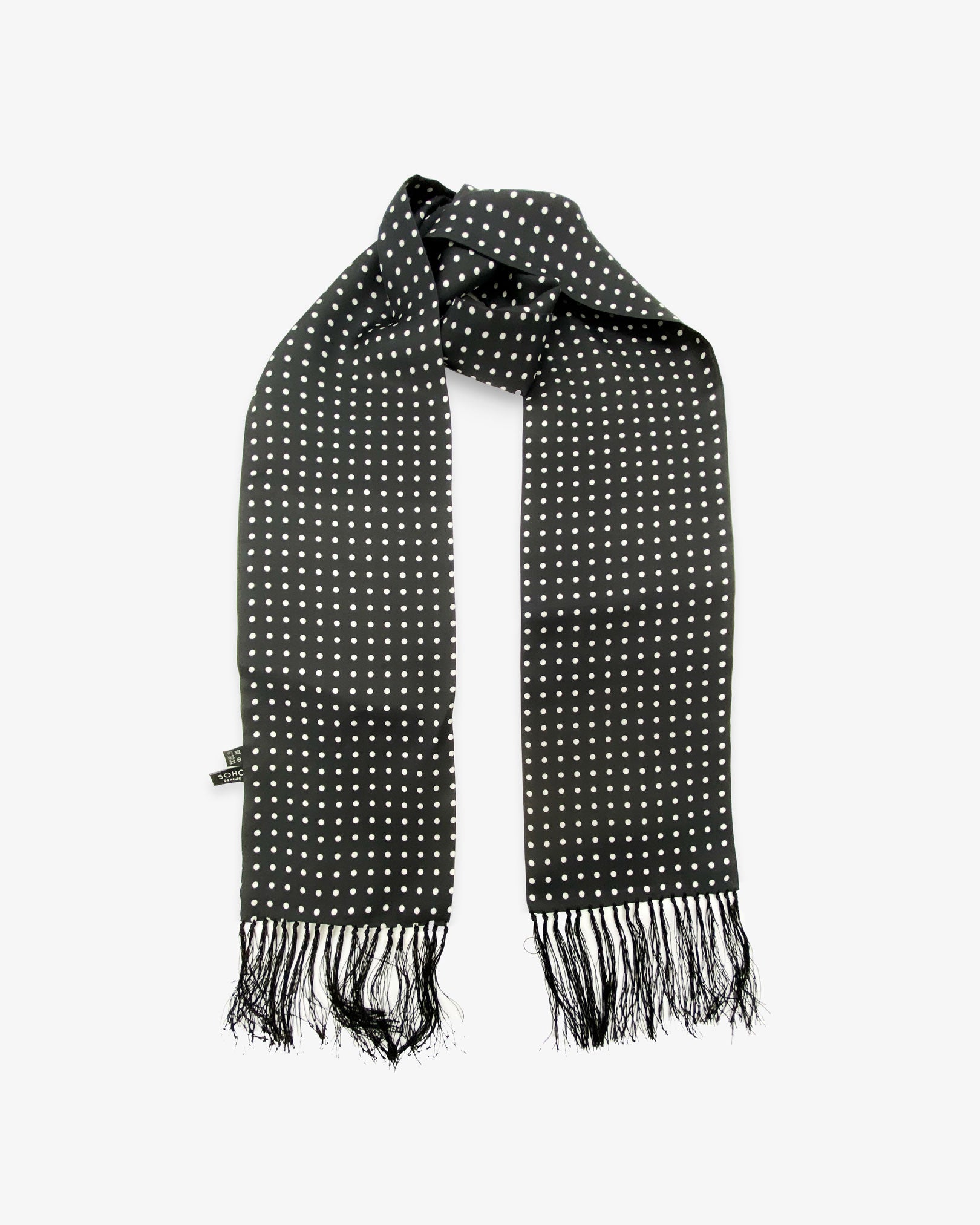 Looped view of the 'Shinagwa' aviator scarf, clearly showing the white polka dot pattern, 'Soho Scarves' branding label on the left and the 3 inch black fringe.