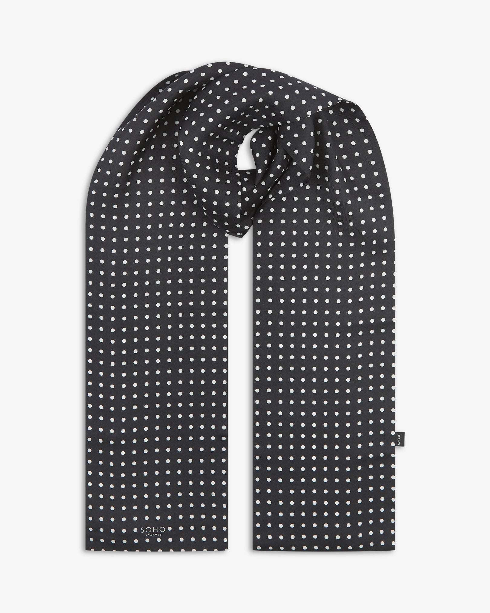Looped view of the 'Shinagwa' silk scarf, clearly showing the white polka dot pattern and 'Soho Scarves' branding label.