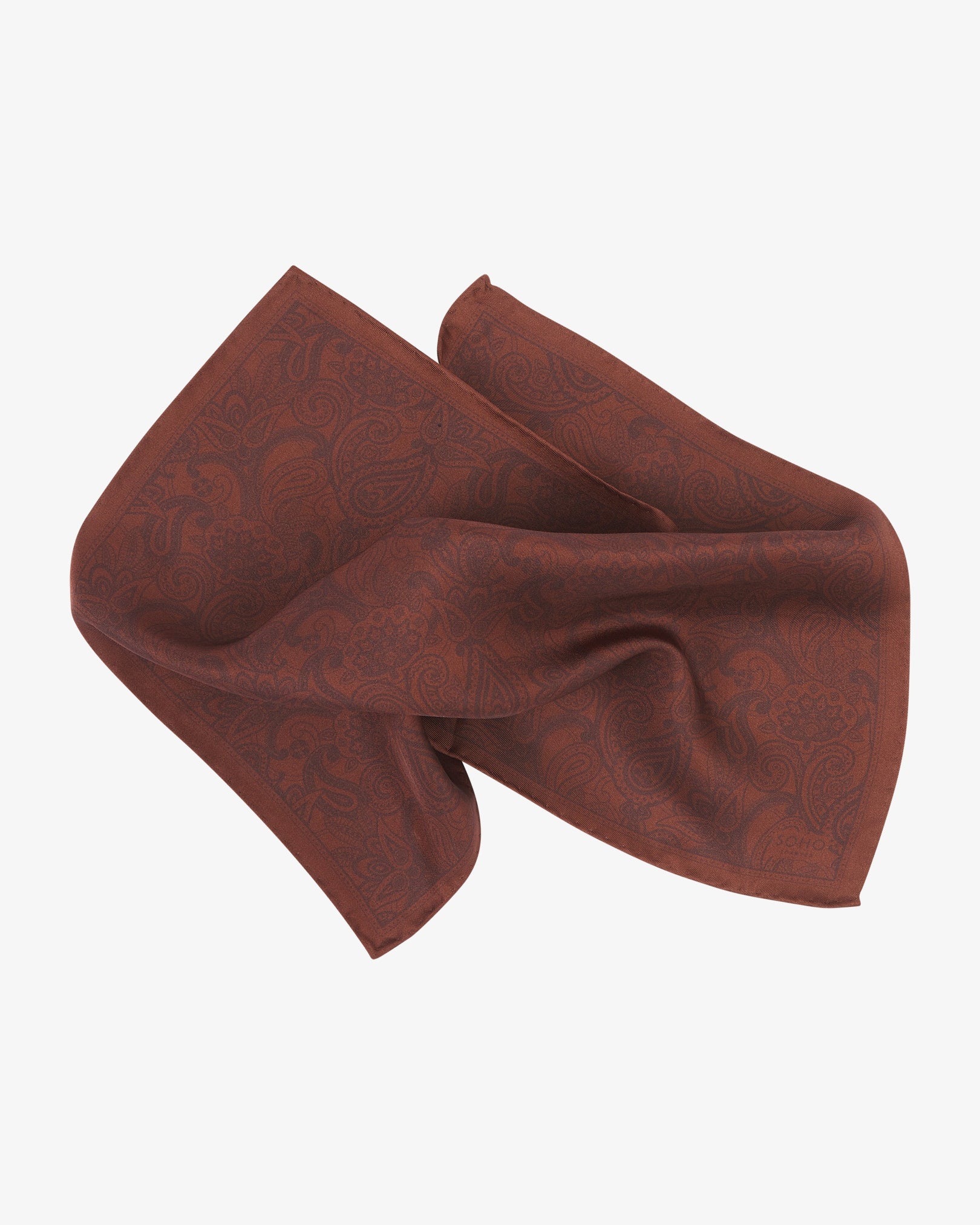 Cocoa silk pocket square from SOHO Scarves, pinched and folded to reveal the rich brown paisley pattern and smooth silk texture.
