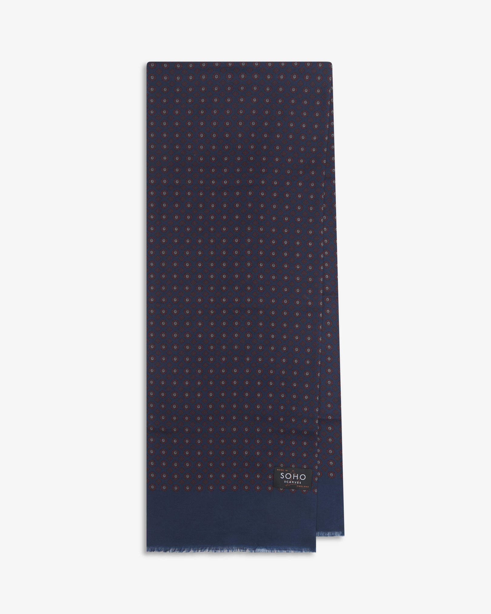 English-made silk and wool scarf arranged in a rectangular shape, displaying the repeating floral-inspired geometric forms in maroon and light blue with blue eyelash fringing.