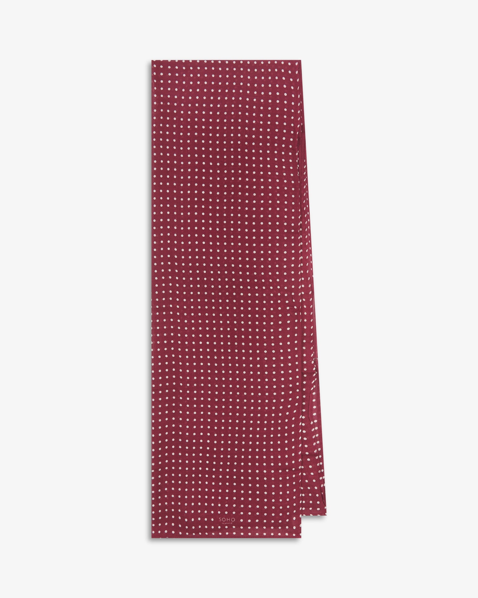 The Sapporo bohemian wide scarf from SOHO Scarves folded and presented vertically to show the full dimensions and classic white polka dot pattern on a maroon background.