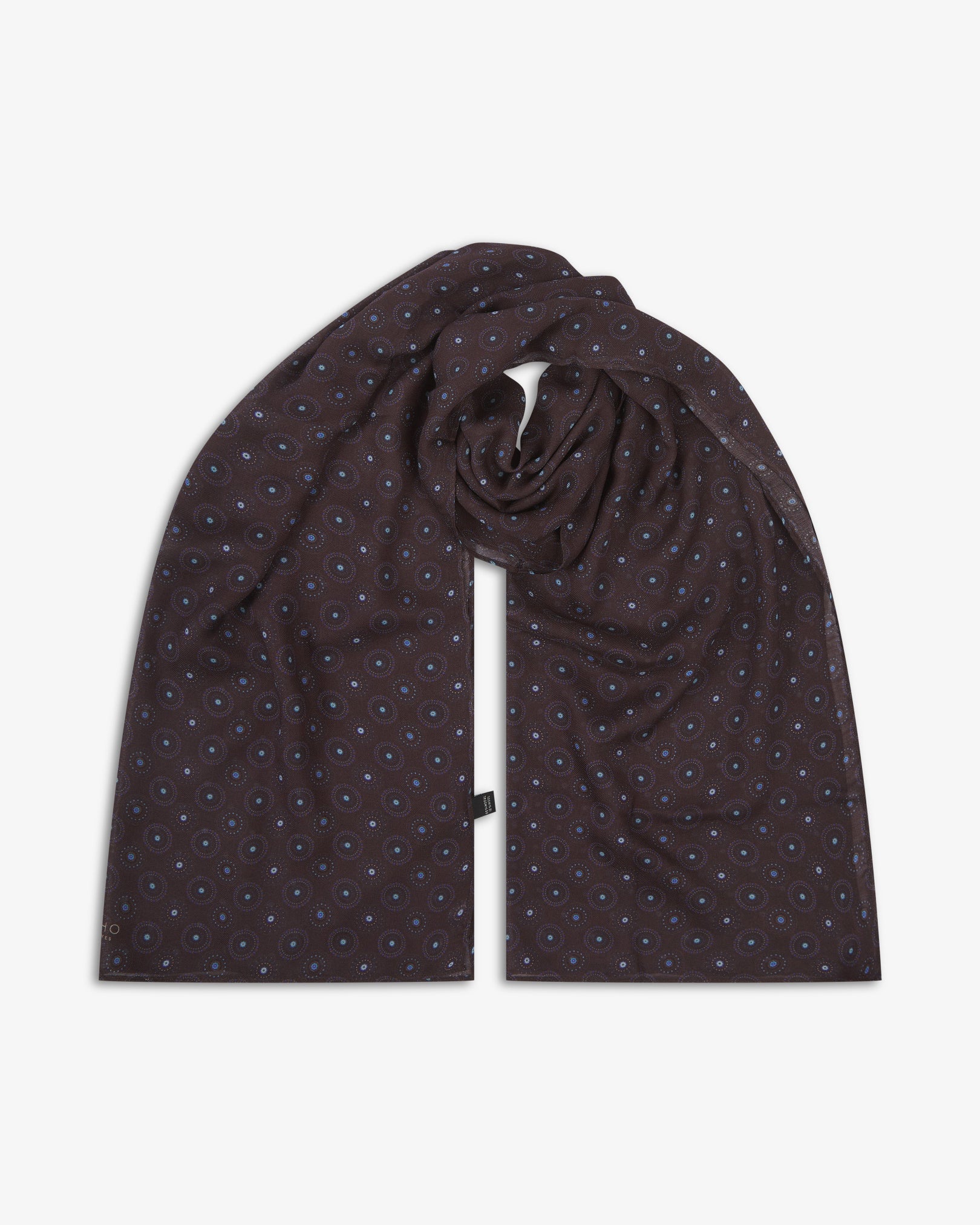 The Seattle 'Mahogany Daze' bohemian wide scarf looped with both ends parallel, showcasing intricate circular motifs in blue and brown on a dark plum background with delicate cream accents across the soft modal and wool blend fabric.