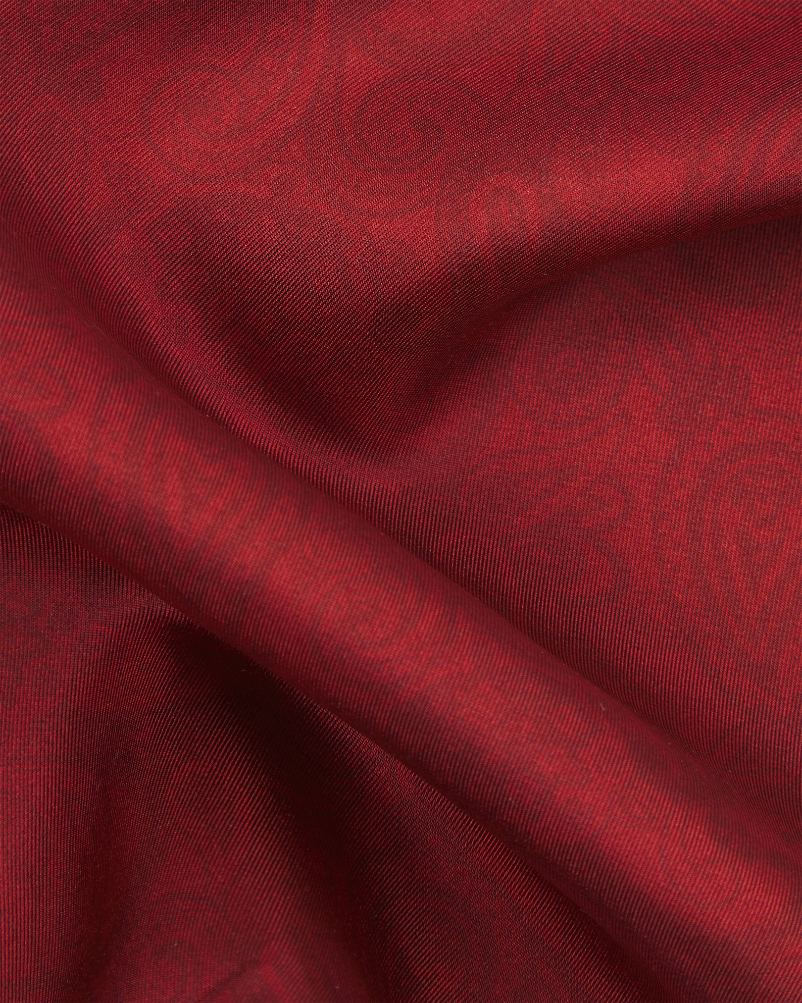Ruffled close-up view of the 'Tonal Paisley' cranberry silk scarf, capturing the soft drape and intricate crimson-on-red paisley pattern woven into the silk side.