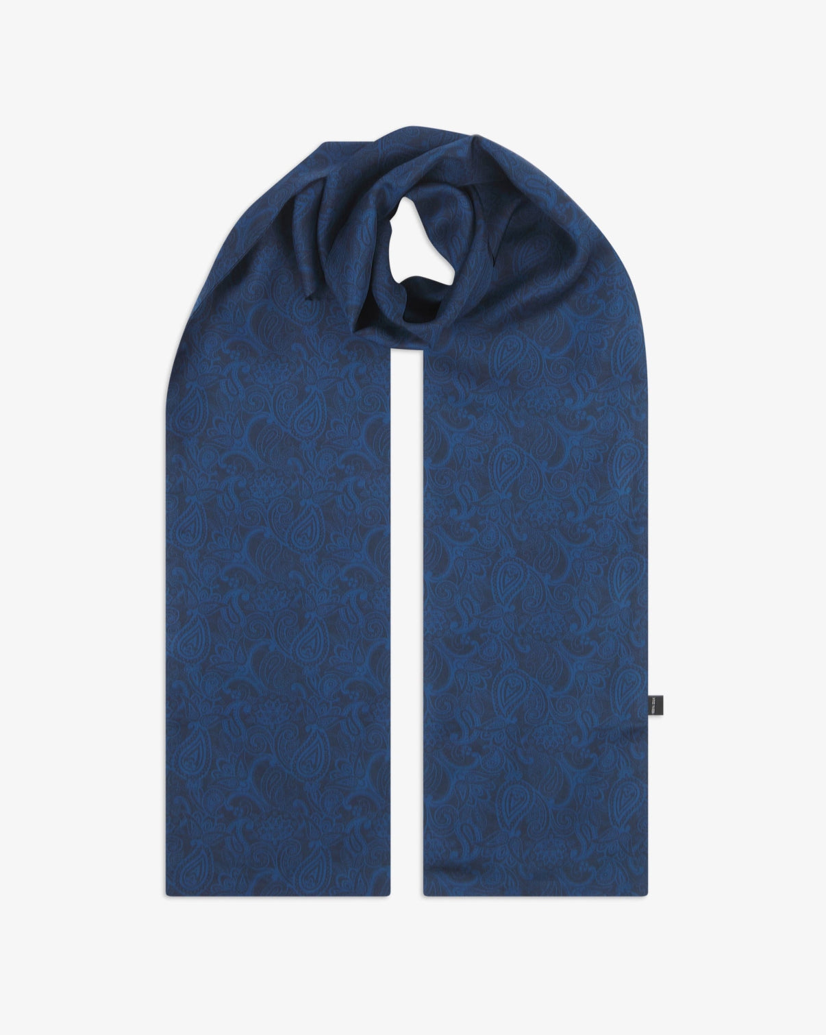 The 'Tonal Paisley' dark navy silk scarf looped with both ends parallel to showcase the full repeat pattern of deep blue paisley motifs on a midnight navy background.