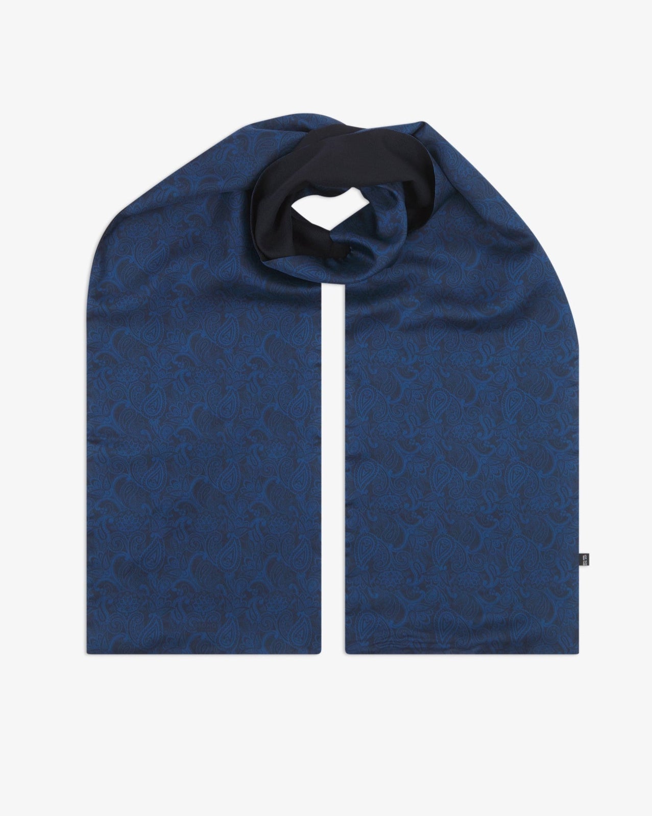 The 'Tonal Paisley' dark navy wool-backed silk scarf, looped at the centre to display the full length of the deep blue paisley silk pattern, with the soft black wool underside showing through.