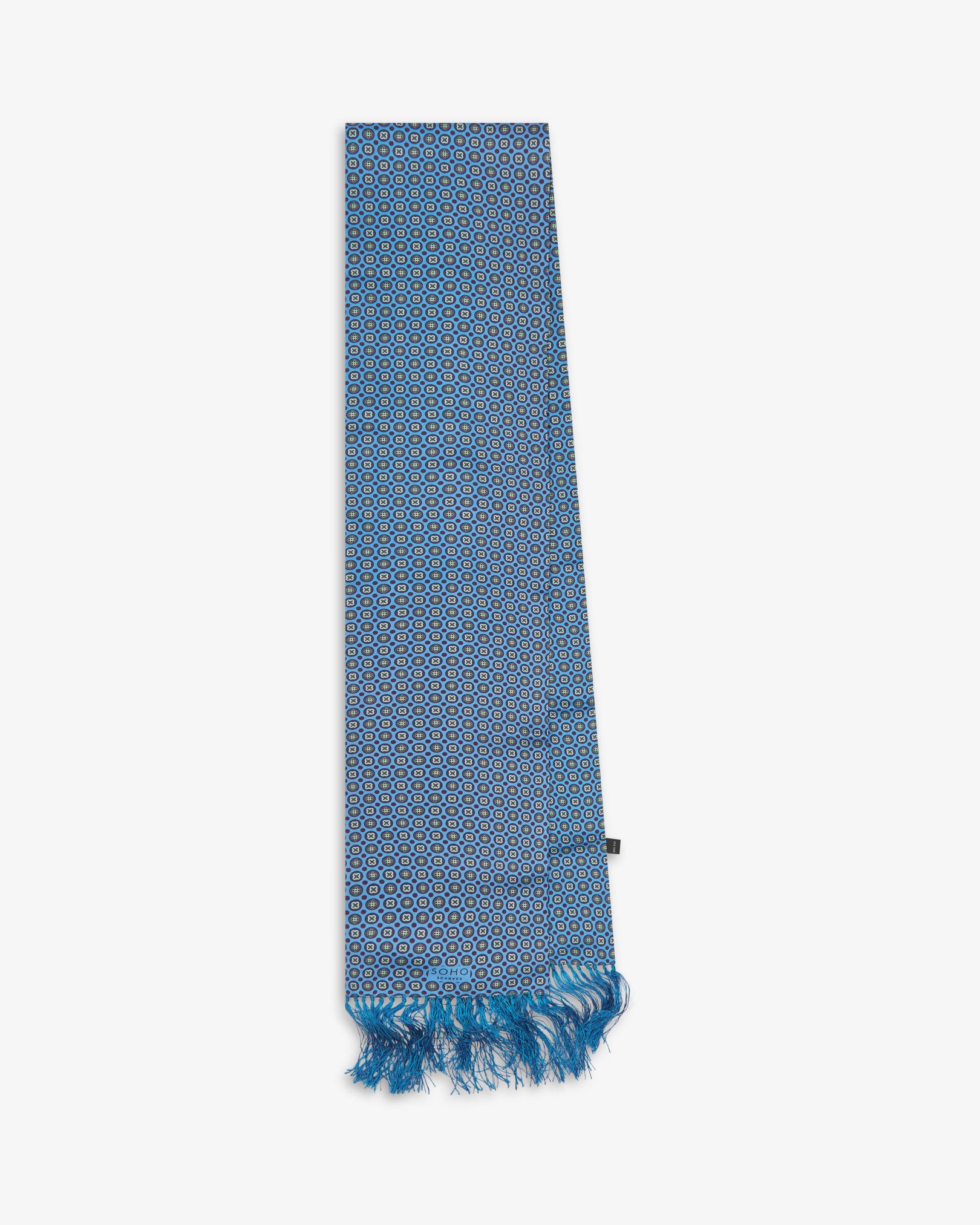 The 'Toshima' Gardenia silk aviator scarf folded and presented vertically illustrating the full scarf dimensions and blue fringe.