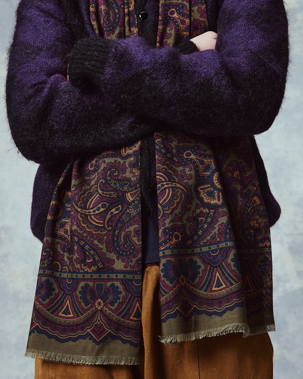 Close-up of man wearing the English-made, 'Paisley in Highland Green' silk and wool scarf, with a clear view of the ornate border which frames the paisley patterns.