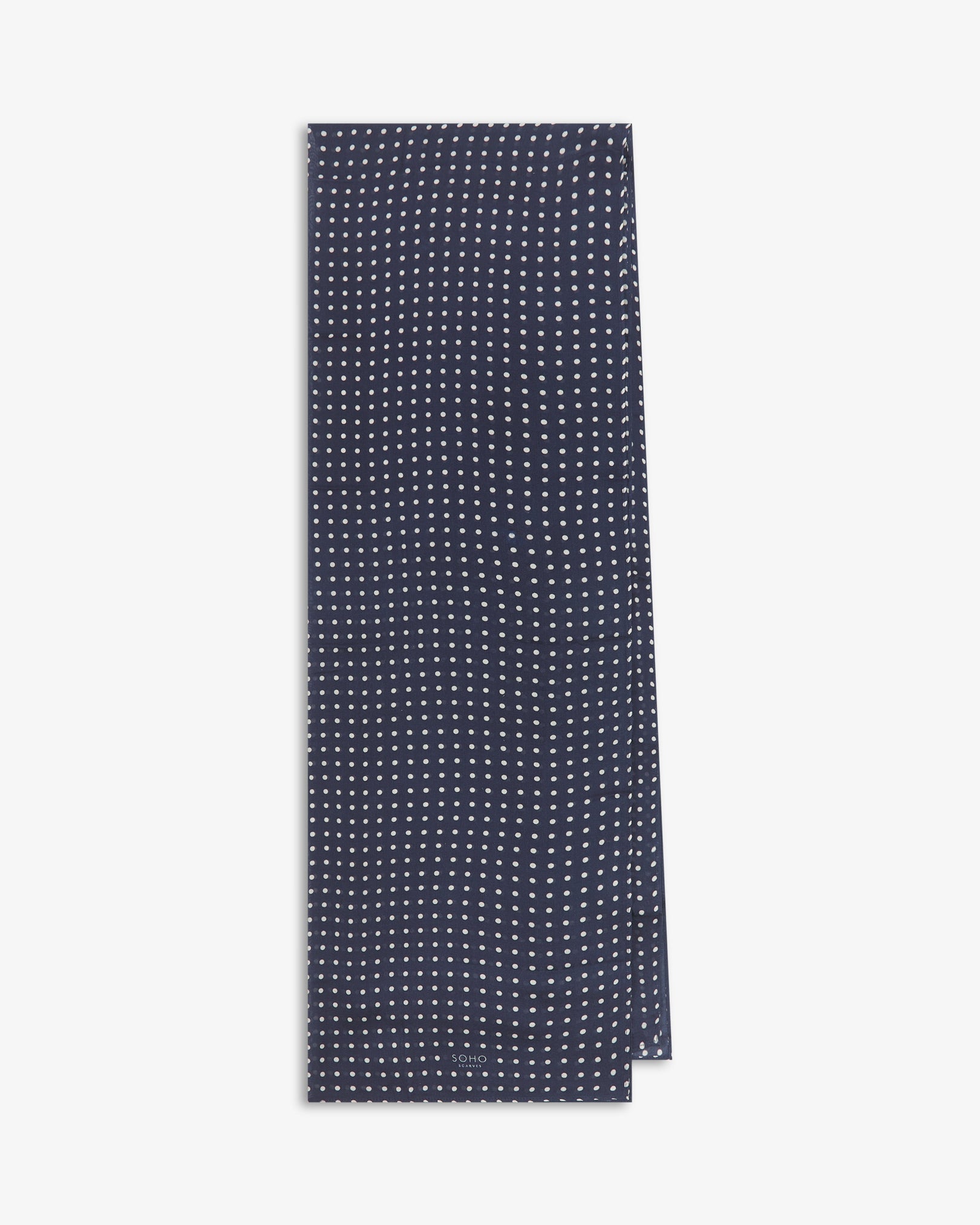 The Westminster bohemian wide scarf from SOHO Scarves folded and presented vertically to show the full dimensions and classic white polka dot pattern on a navy blue background.