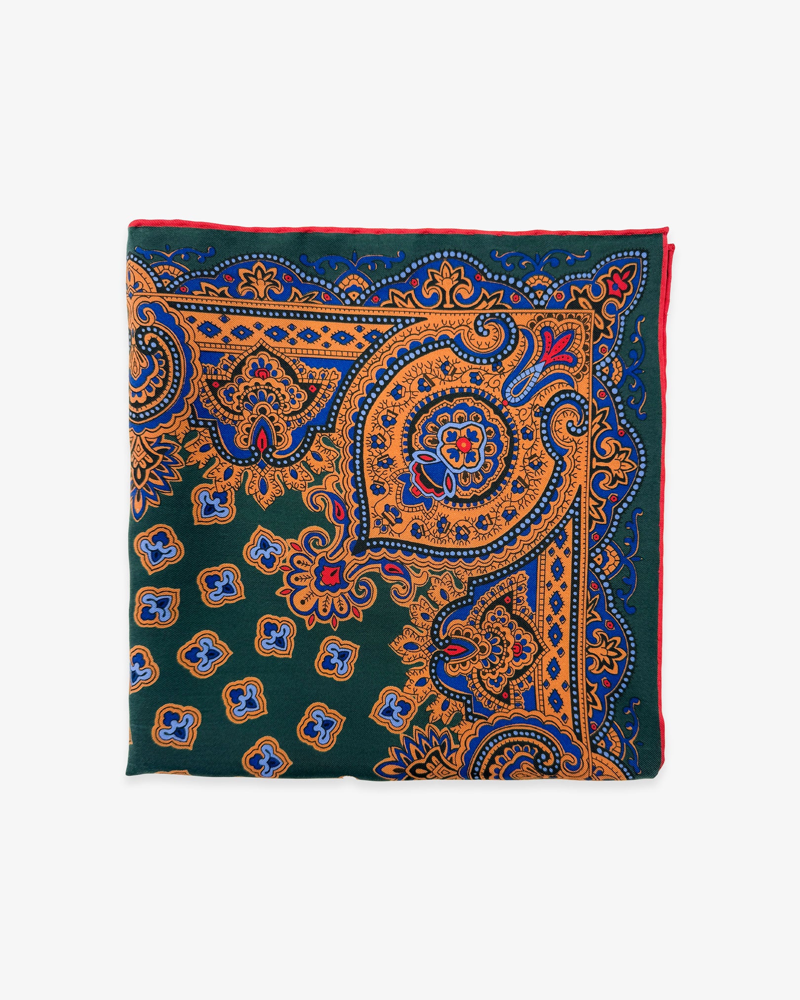 The 'Abingdon' pocket square from SOHO Scarves Madder silk collection. Folded into a quarter, showing the various traditional stylised forms in green, gold and blue.