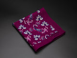 Wool 'Madurai' pocket square folded showing simple paisley 'tears' and decorative floral patterns on a purple ground. SOHO Scarves branding clearly visible on bottom-right.