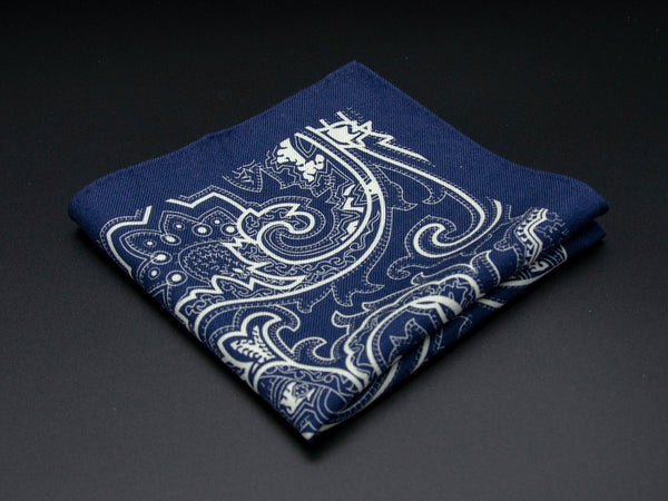 Pure wool 'Kakumae' navy pocket square folded into a quarter, clearly showing the large white swirling paisley motif.