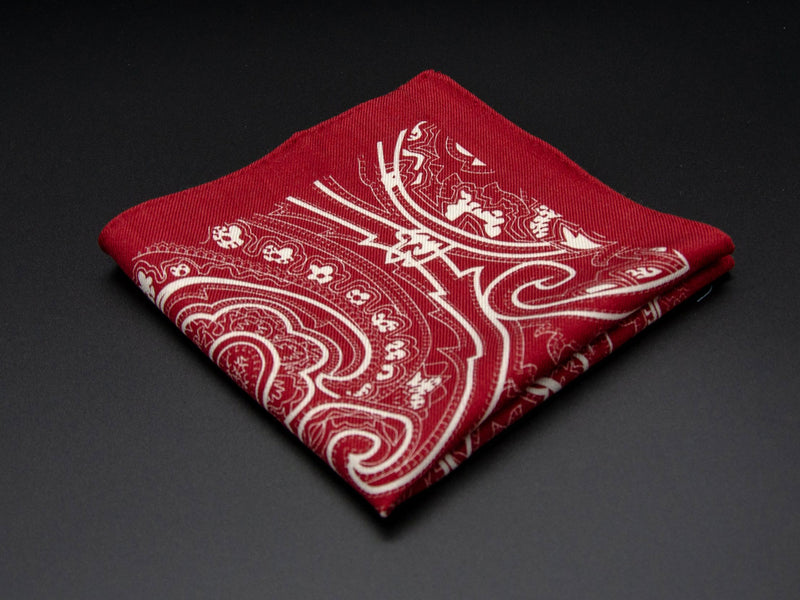 Pure wool 'Kalamaja' red pocket square folded into a quarter, clearly showing the large white swirling paisley motif.
