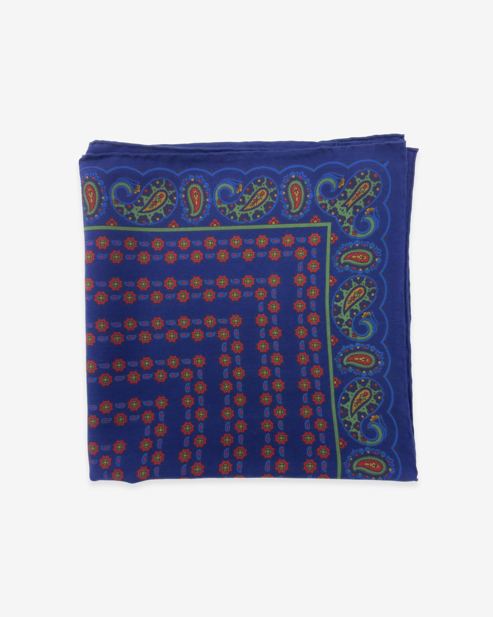 The 'Ballowall' pocket square from SOHO Scarves Madder silk collection. Folded into a quarter, showing the ornate decorative patterns against a blue background.