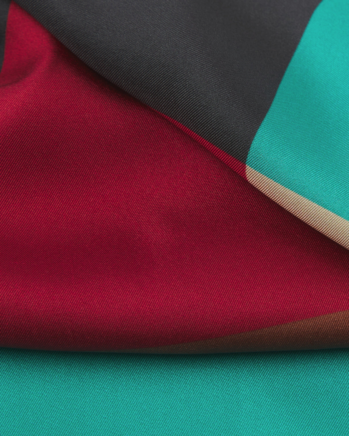 A ruffled close-up of the 'Berlin' silk neckerchief, presenting the interplay of the Bauhaus inspired palette.