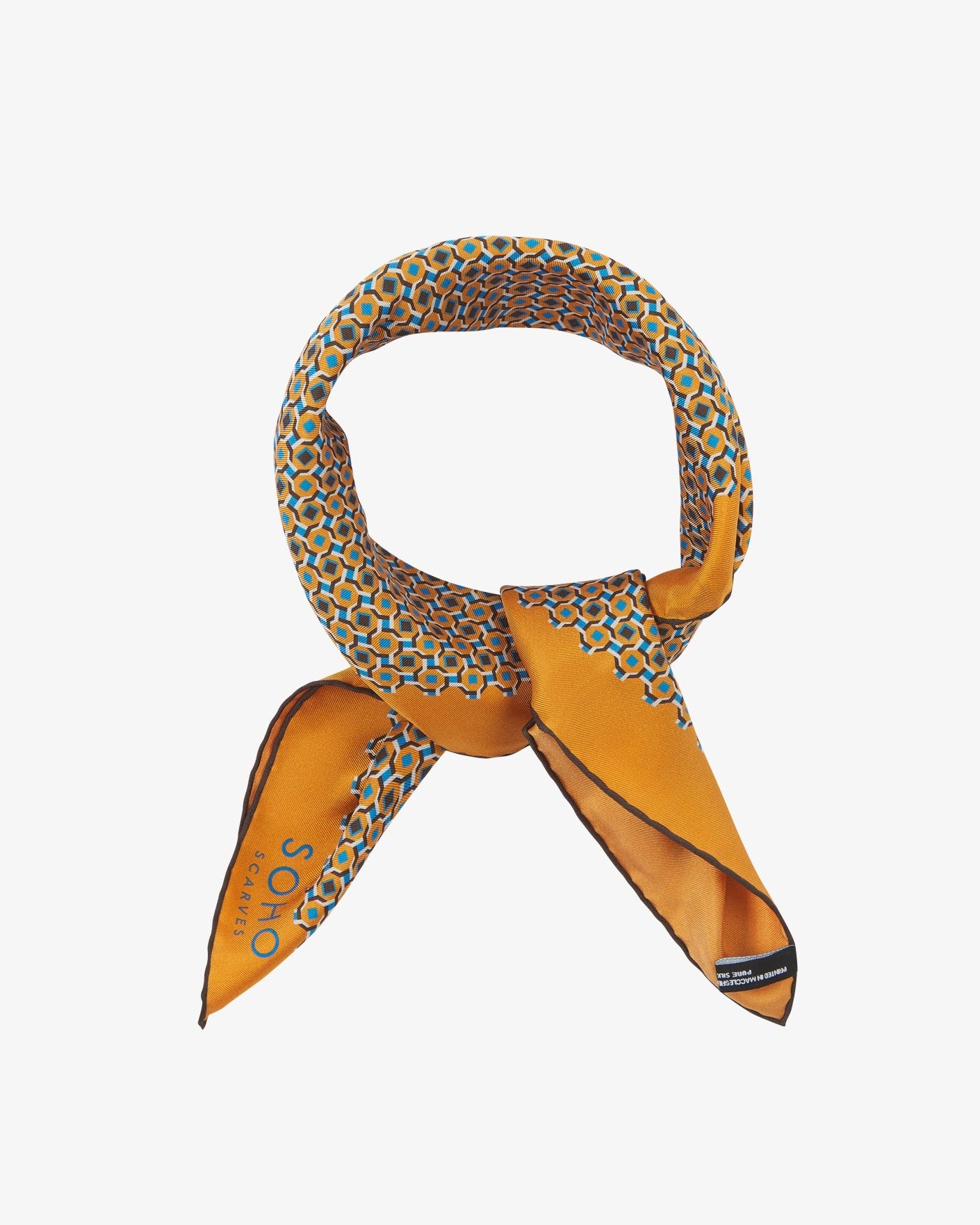 The 'Berwick' neckerchief looped and knotted, highlighting the golden-orange silk and its sharp geometric print in turquoise, chocolate, and cream.