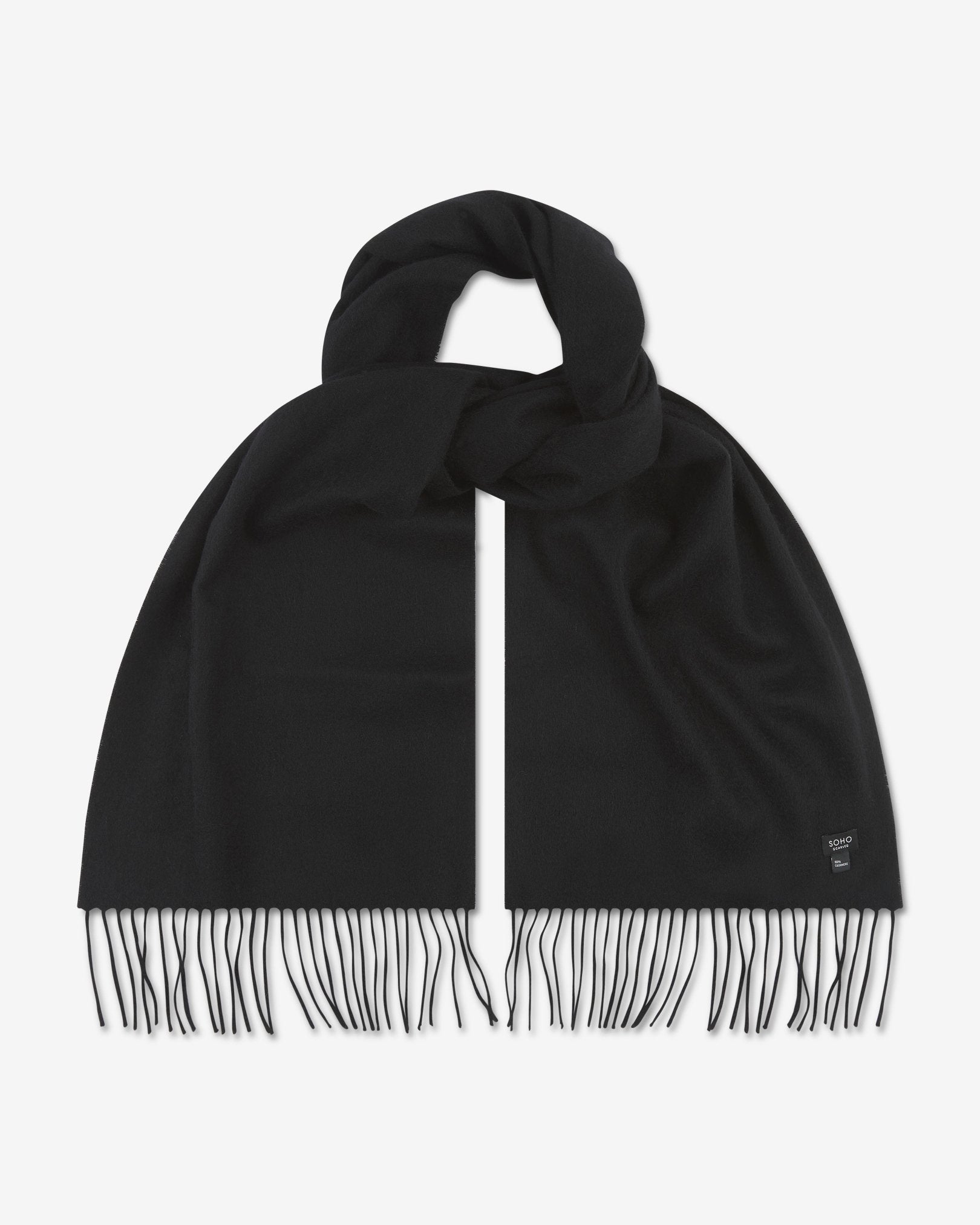 Looped black cashmere scarf with both ends parallel and fringe extended. View of SOHO Scarves branding label on bottom-right portion of the scarf.
