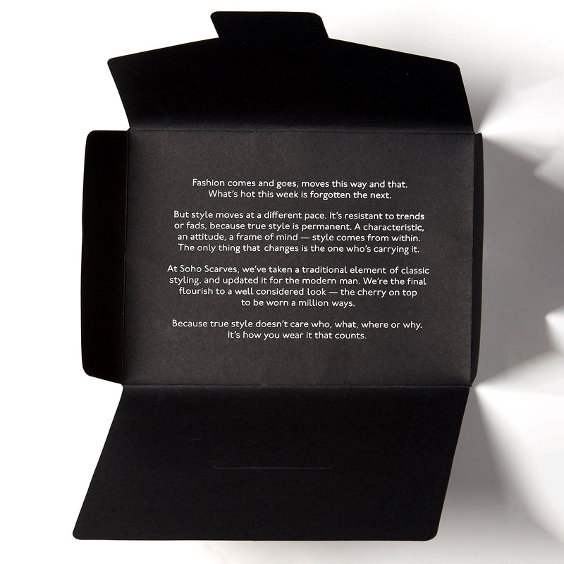Opened black packaging for scarf from Soho Scarves, containing style manifesto.