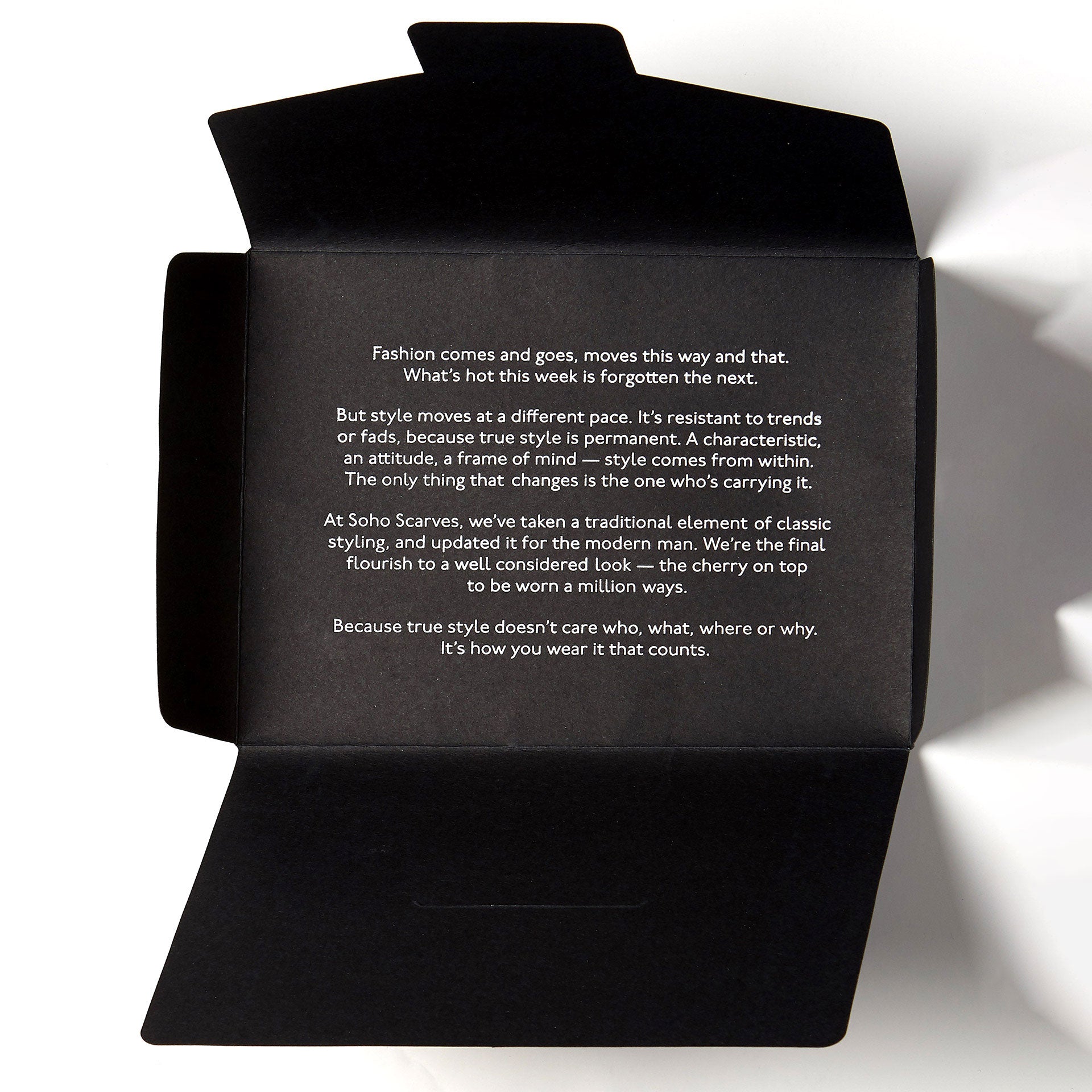 Opened black packaging for wide bohemian scarf from Soho Scarves, containing style manifesto.