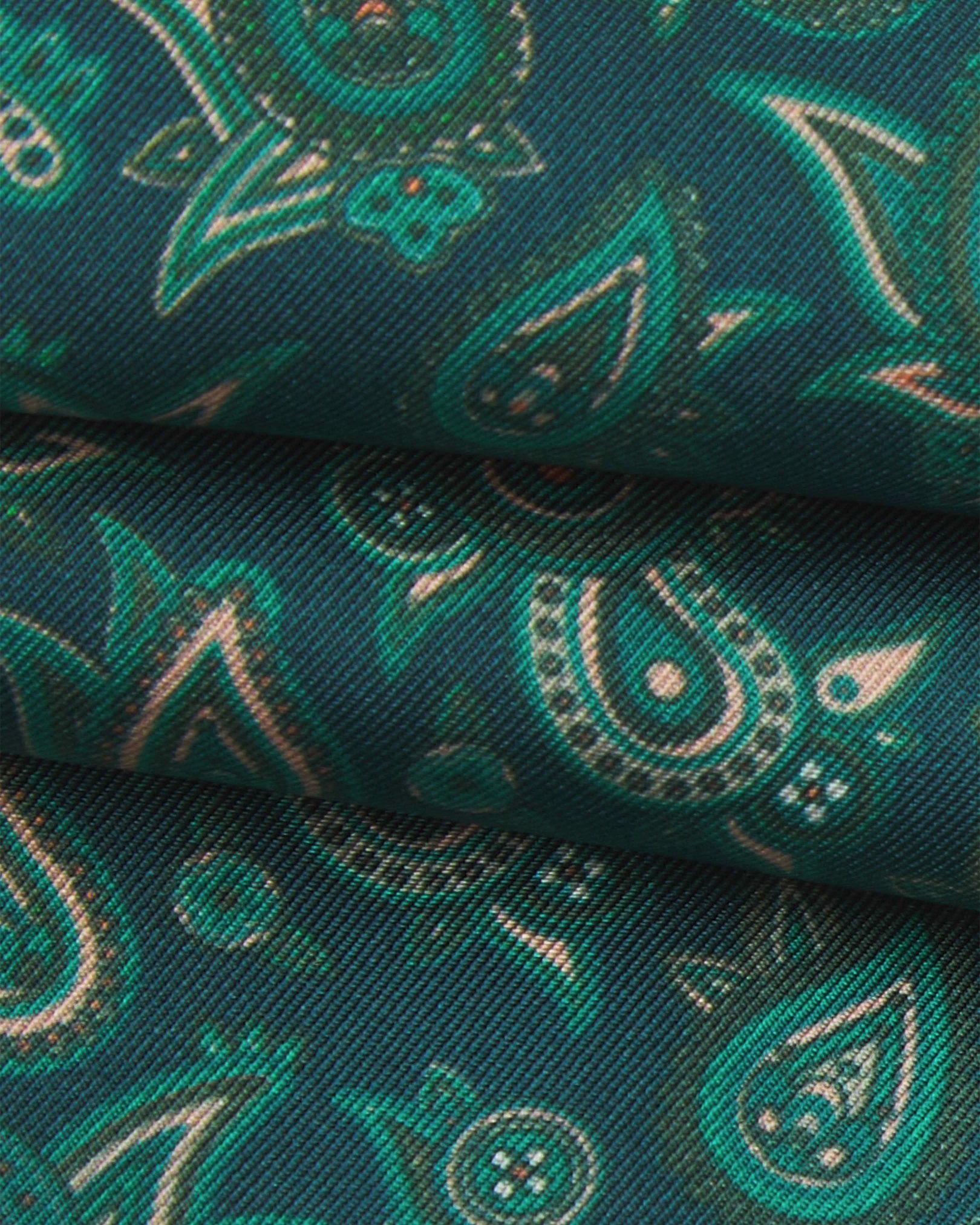 A ruffled close-up of the 'Buttermere' emerald-green silk aviator scarf, presenting the overlapping elements of green and salmon pink paisley patterns.