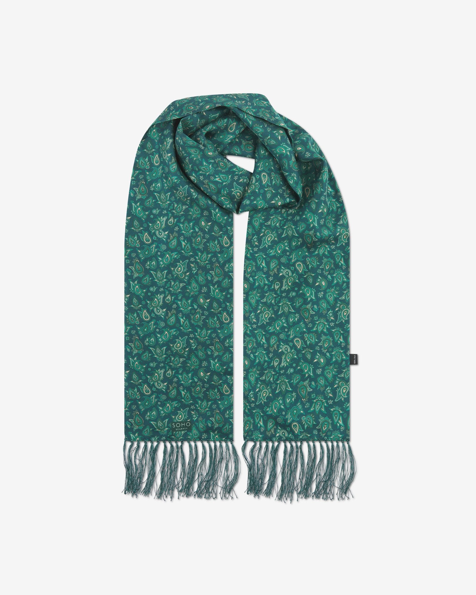 The 'Buttermere' emerald-green silk aviator scarf looped with both ends parallel to effectively display the full repeat pattern of green and salmon pink paisley patterns and fringes.