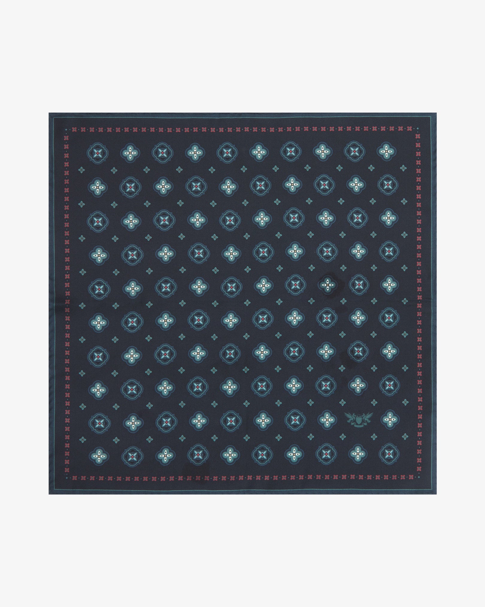 Fully unfolded 'Chelsea' silk pocket square, clearly displaying teal quatrefoil medallions with crimson star accents and pale teal cross motifs on a deep midnight navy ground, framed by a slim crimson-pink border with fine dot detail.