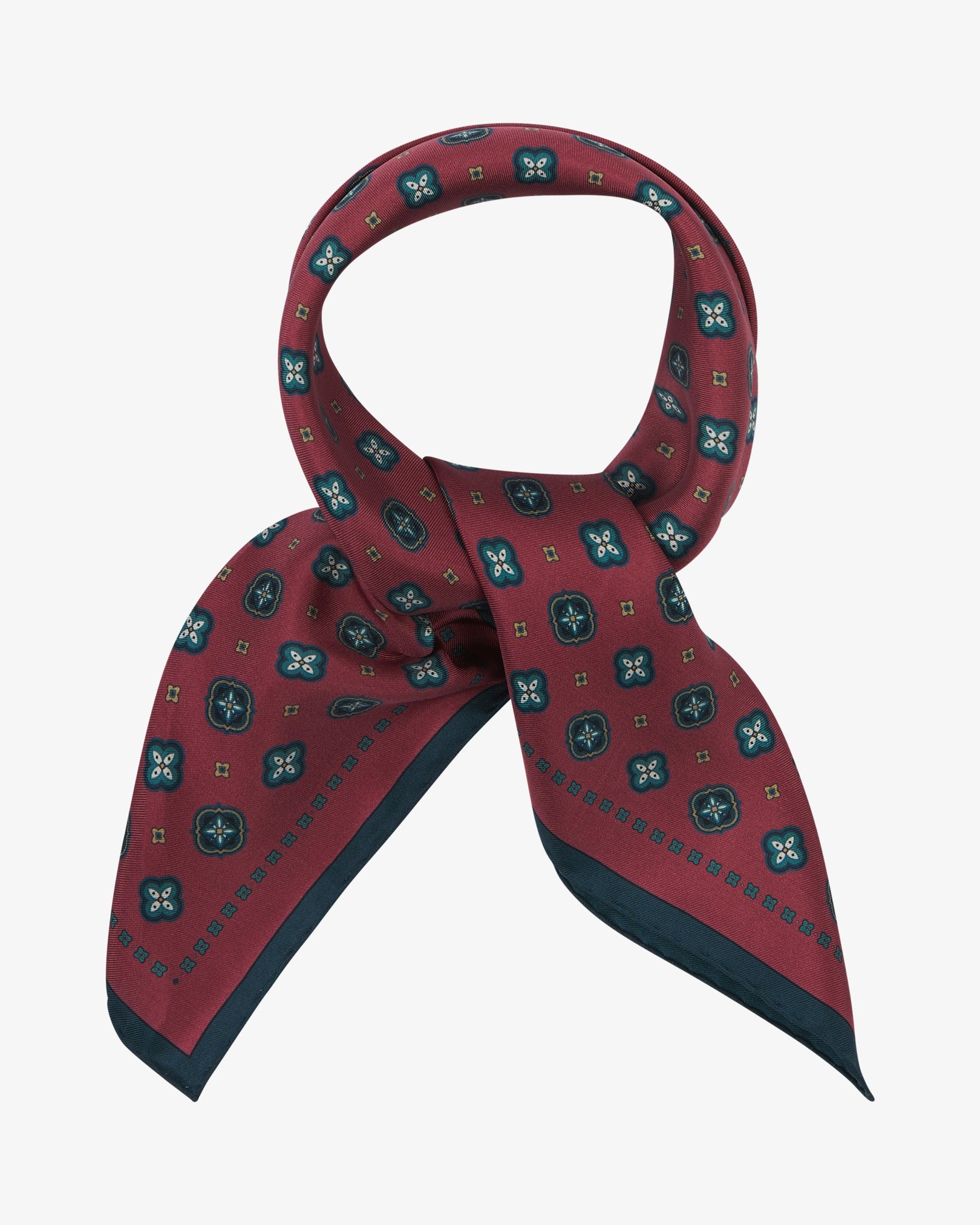 The 'Chelsea' neckerchief looped and knotted, revealing an ornate geometric floral pattern on a rich berry silk ground, accented with teal, cream and gold detailing, and finished with a deep teal border and a subtle silk lustre.