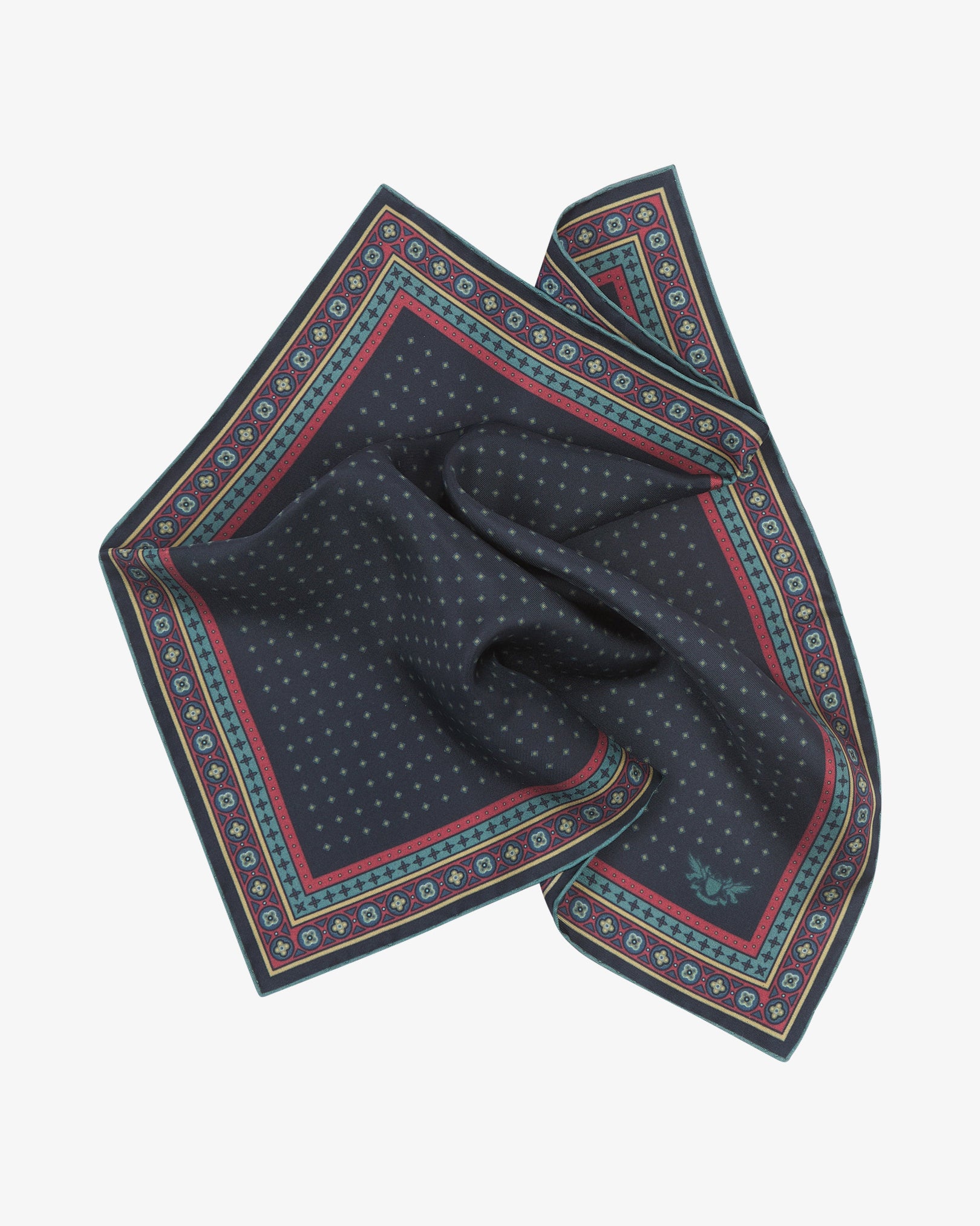 The 'Chiswick' silk pocket square softly pinched and gathered at the centre, presenting the fine teal micro-diamond lattice on a deep midnight navy ground, framed by an ornate border with gold, crimson and teal quatrefoil detailing.
