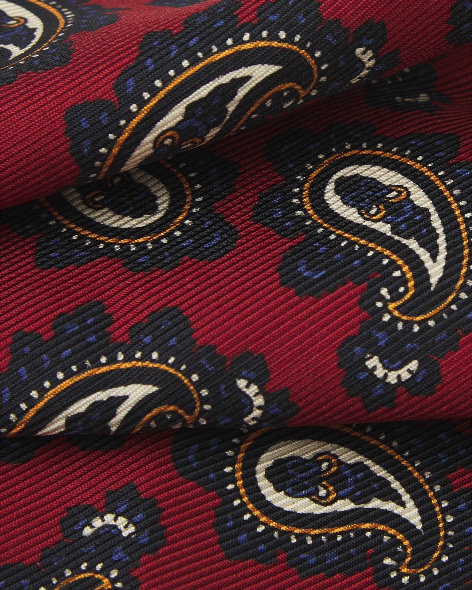 A ruffled close-up of the 'Binham' pocket square, presenting a closer view of the paisley patterns against the attractive lustre of the deadstock silk material. 