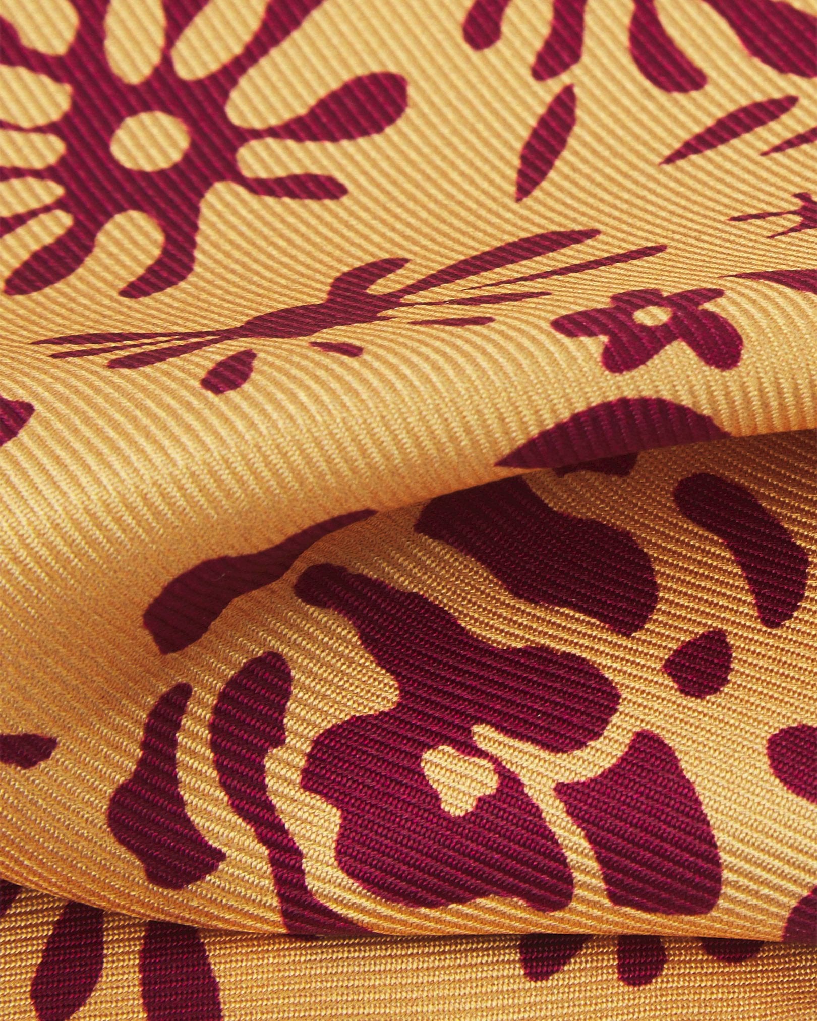 A ruffled close-up of the 'Blenheim' pocket square, presenting a closer view of the floral-inspired patterns against the attractive lustre of the deadstock silk material. 