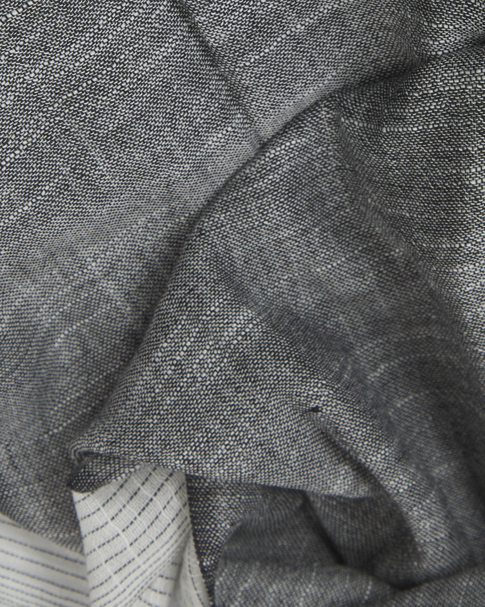 Ruffled close-up view of the UK-made, pure cotton 'Bonington' scarf, presenting a closer view of the black and white yarns which make up the transitional, gradient pattern.