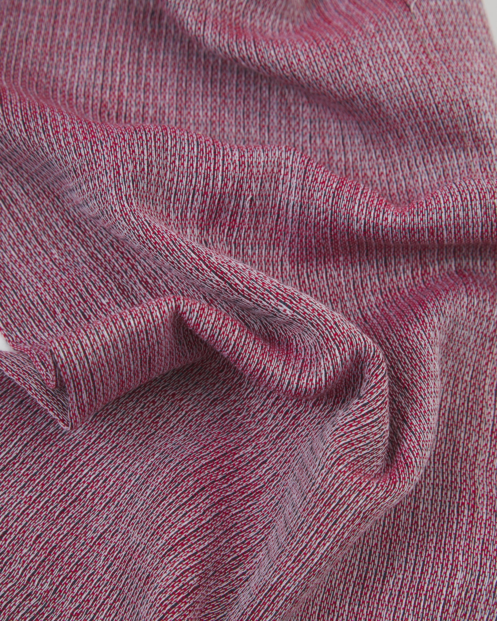 Ruffled close-up view of the UK-made, pure cotton 'Brown' scarf, presenting a closer view of the red, white and black yarns which make up the marled, two-tone pink style.