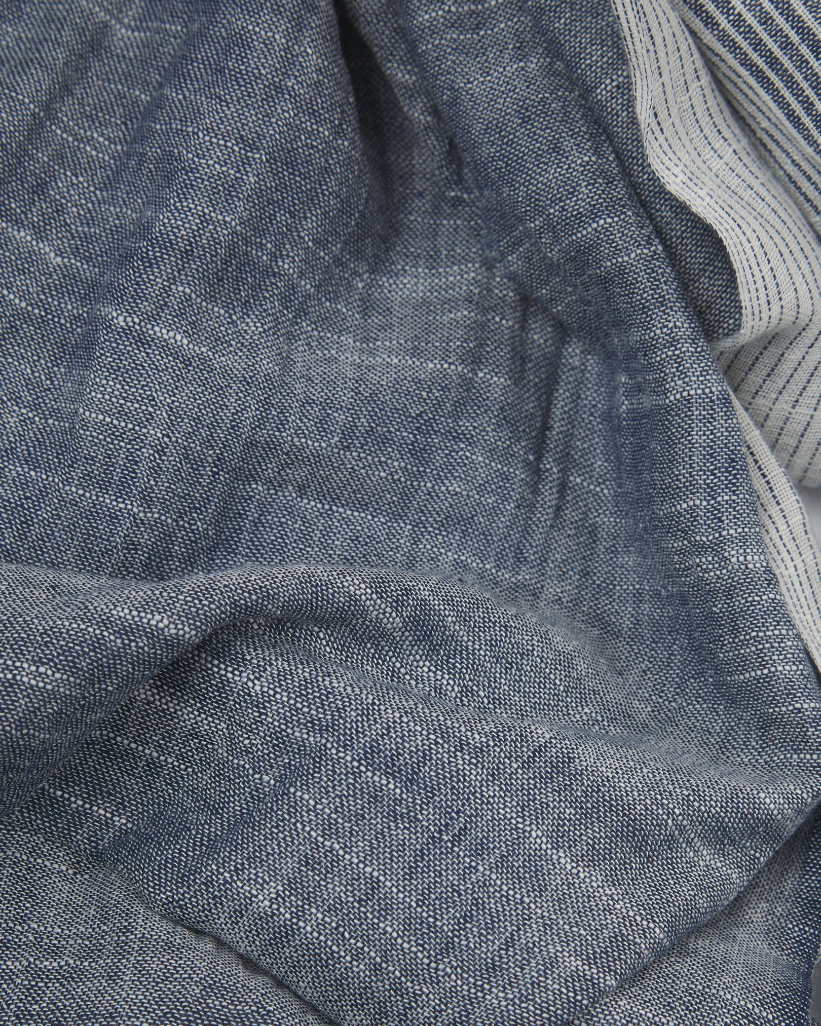 Ruffled close-up view of the UK-made, pure cotton 'Hargreaves' scarf, presenting a closer view of the navy and white yarns  which make up the transitional, gradient pattern.