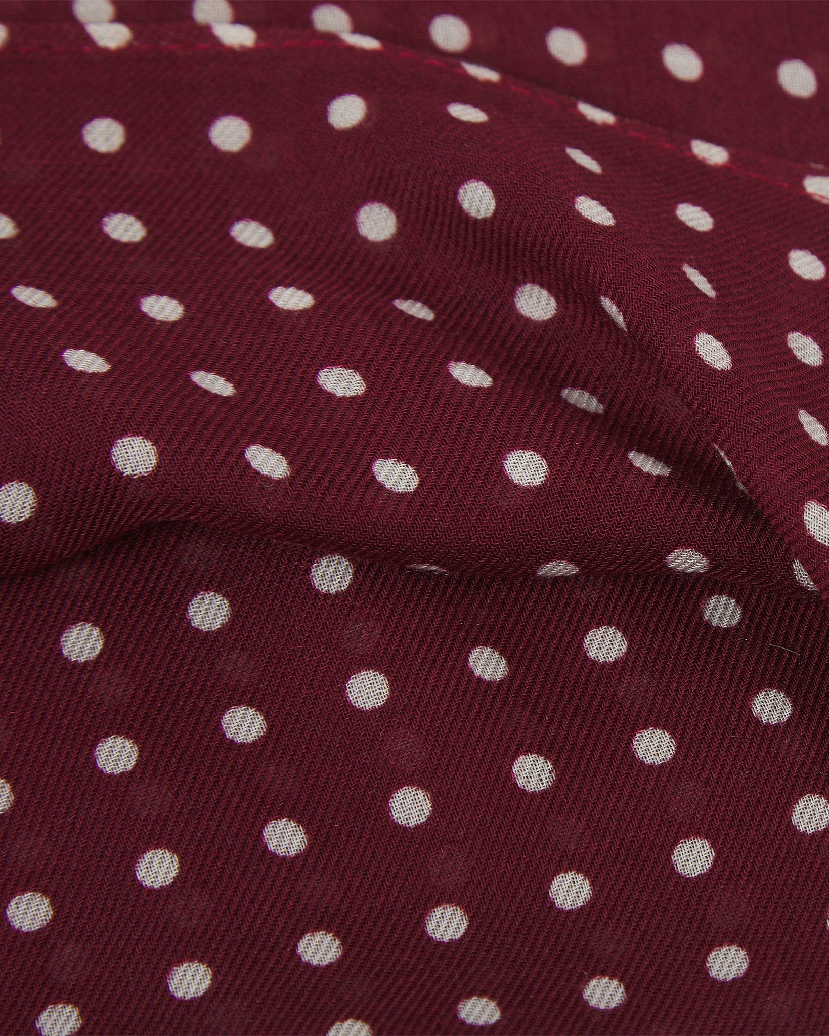 Close-up view of 'Sapporo' bandana. Ruffled and clearly showing the texture of the modal-wool blend and the polka dot pattern.