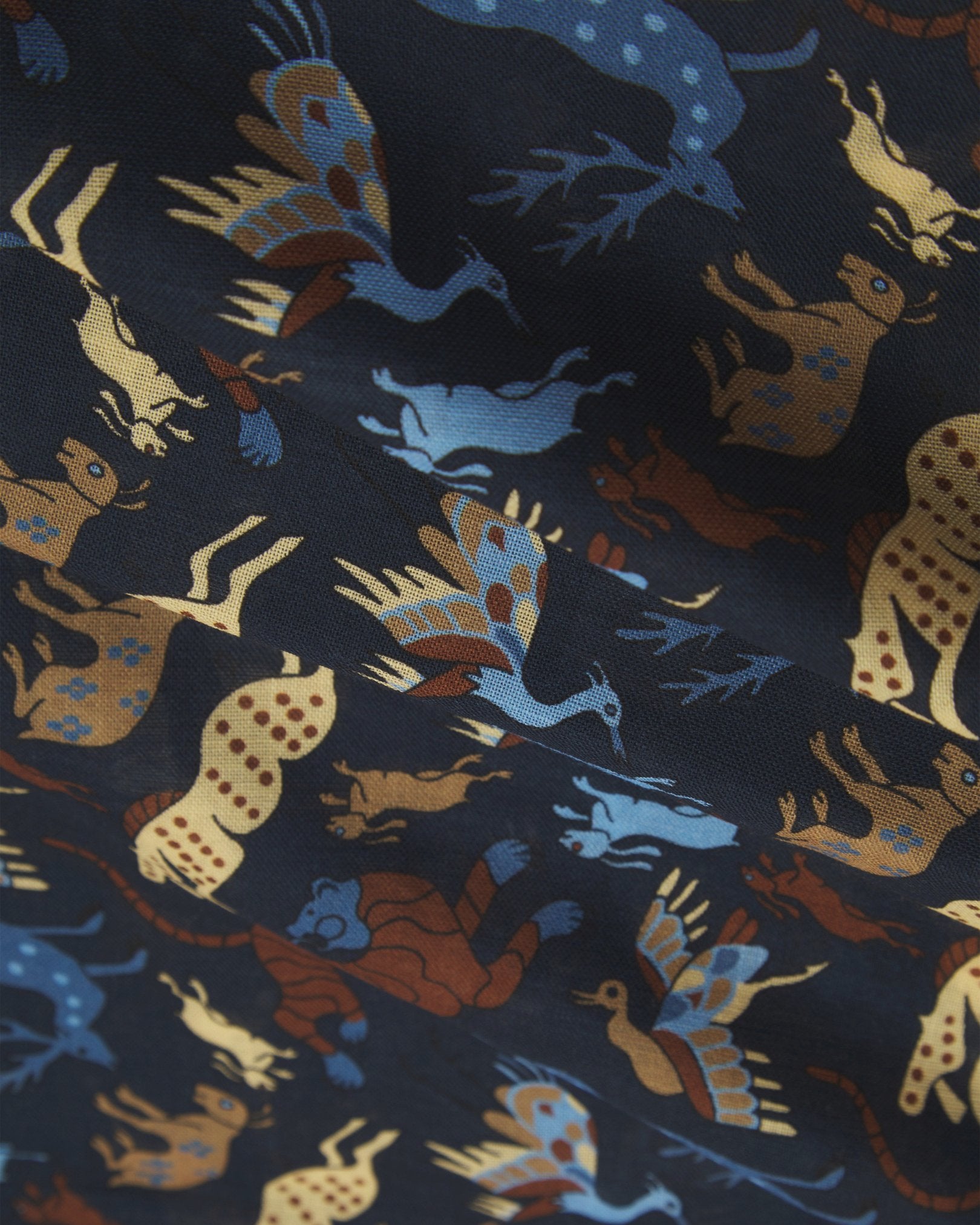 A flat, close-up view of the UK-made ‘Airforce-blue’ silk-wool scarf with stylised woodland creatures. Clearly showing the premium silk and wool weave and the detailed multicoloured animal and floral patterns against an Airforce Blue background.