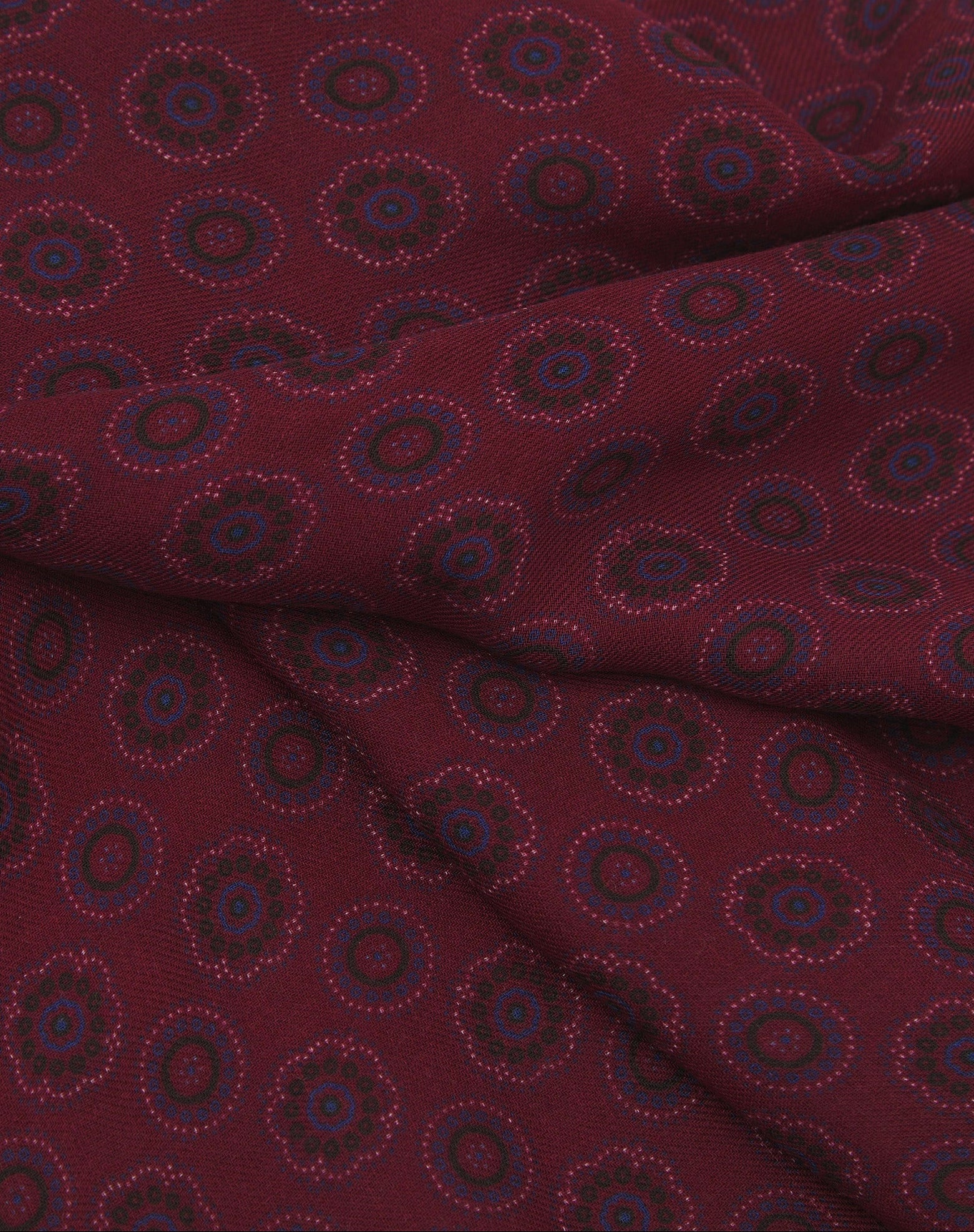 A ruffled close-up of the 'Seattle' modal and wool bandana, presenting a closer view of the blue circle and floral-inspired patterns and modal weave.