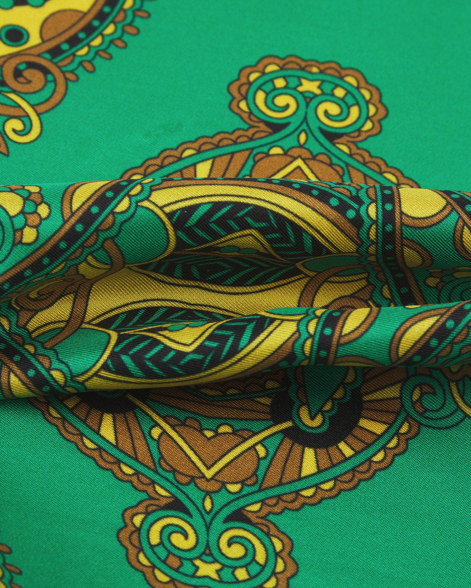 A ruffled close-up of the 'Forks' double ascot from SOHO Scarves, showing overlapping elements of the golden patterns