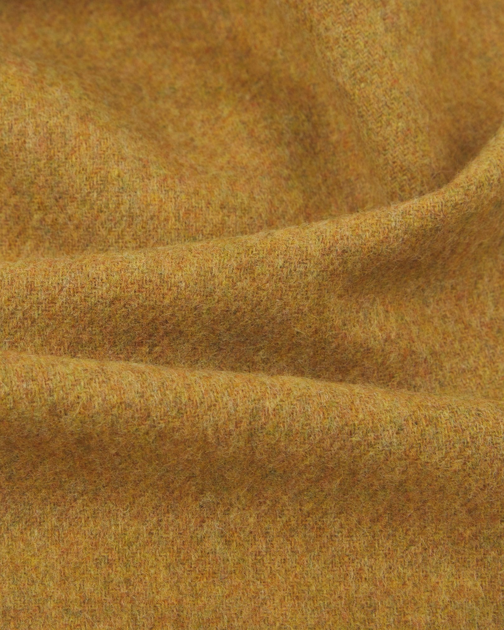 Ruffled close-up view of the UK-made, pure Merino wool 'lowlands' tartan dress in gold scarf, presenting a closer view of the premium woollen fabric.