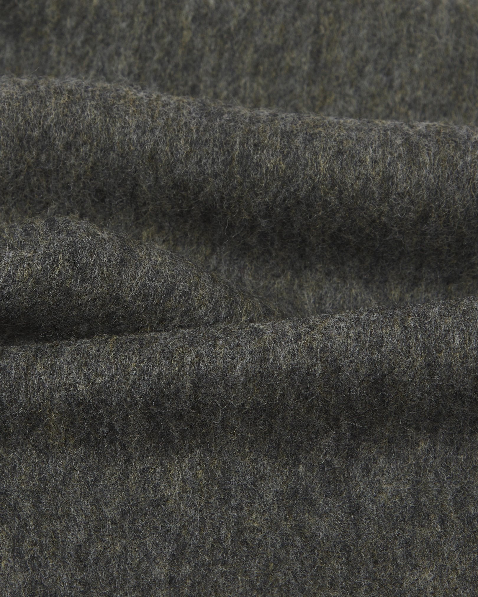 Ruffled close-up view of the UK-made, pure Merino wool 'lowlands' tartan dress in grey scarf, presenting a closer view of the premium woollen fabric.